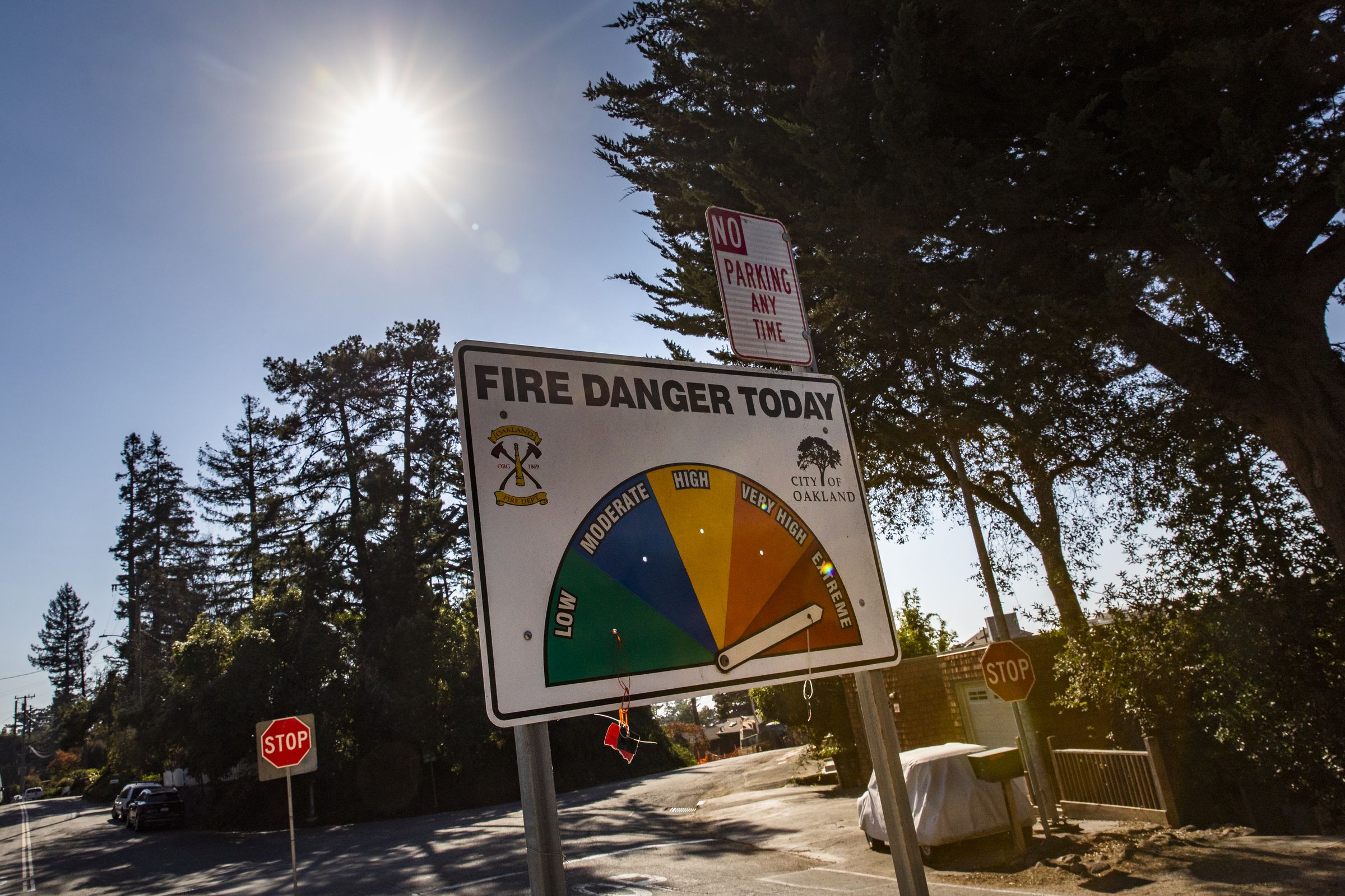 A street sign in a residential neighborhood says “Fire Danger Today” with an arrow point to “extreme”
