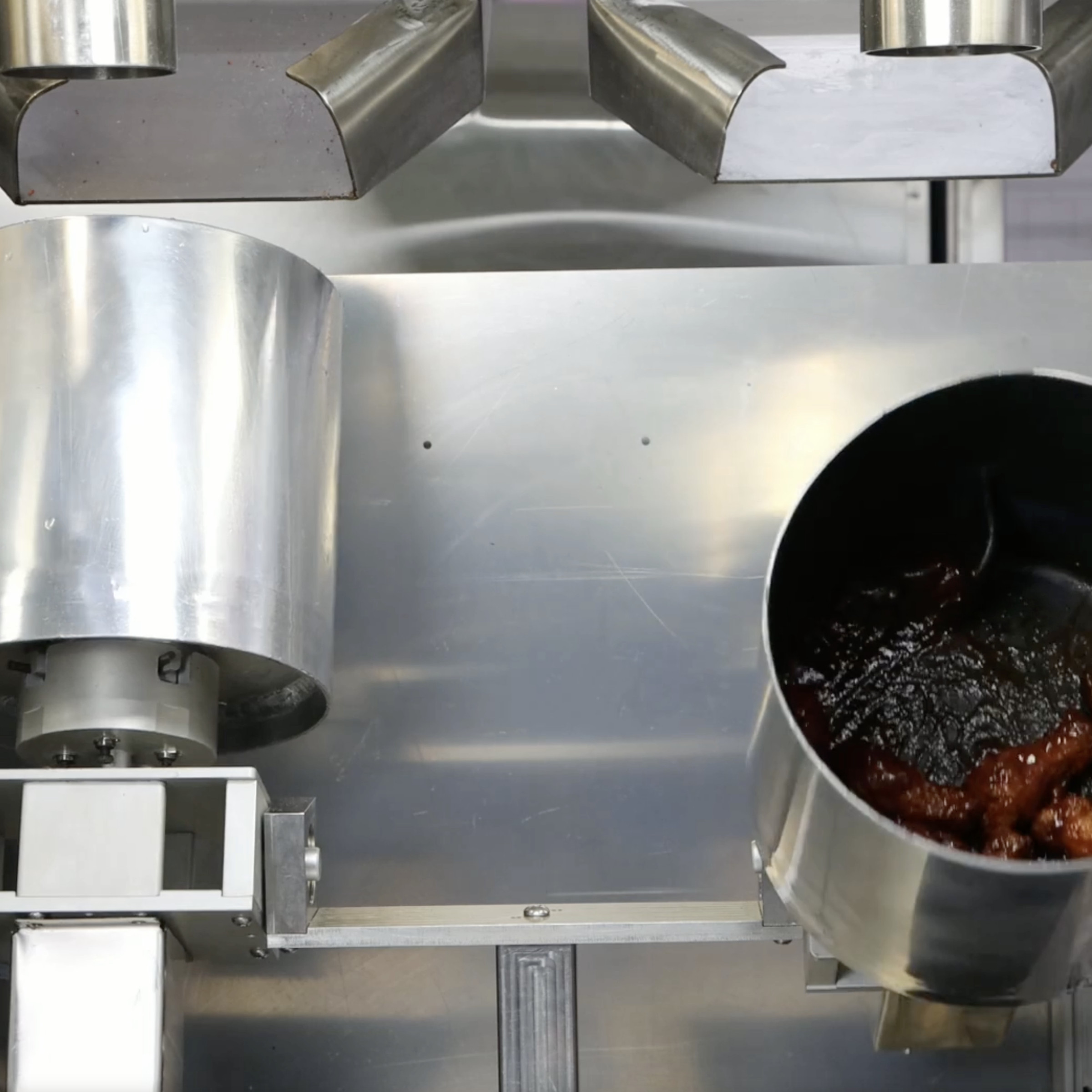 A picture of stainless steel buckets used by Nala Robotics’ robotic fry station.