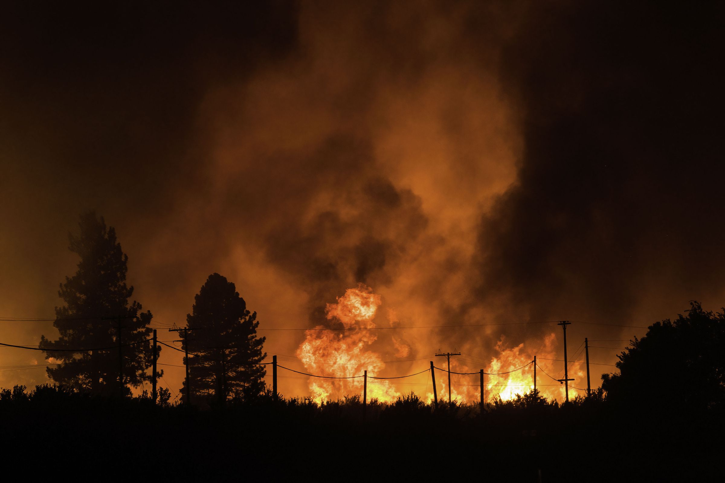 Flames from the Dixie fire approach powerlines. The Dixie...