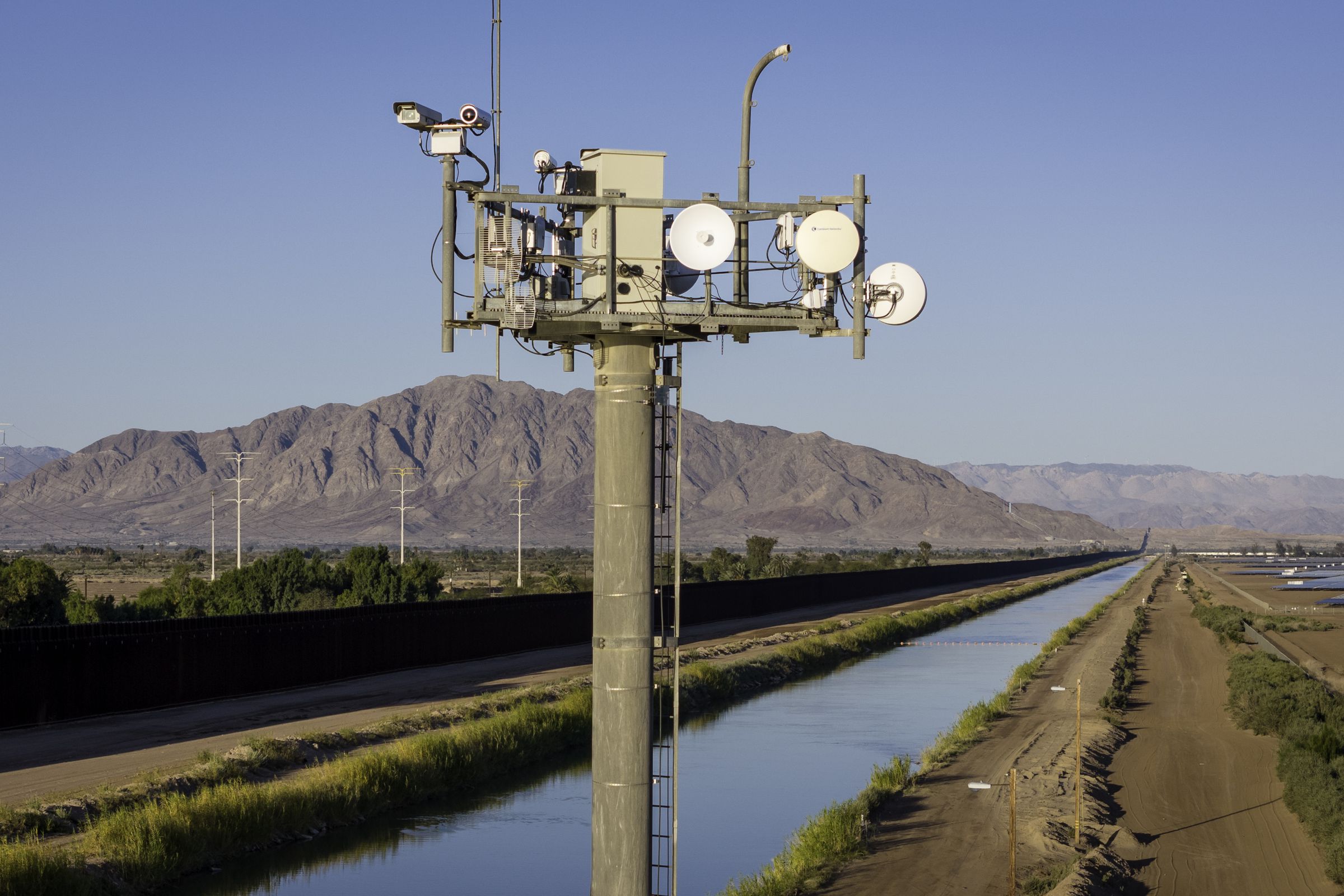 In an aerial view, cameras on a U.S. Customs and Border Protection (CBP) surveillance tower monitor activity along the U.S.-Mexico border fence and the All-American Canal on March 8, 2024 in Calexico, California