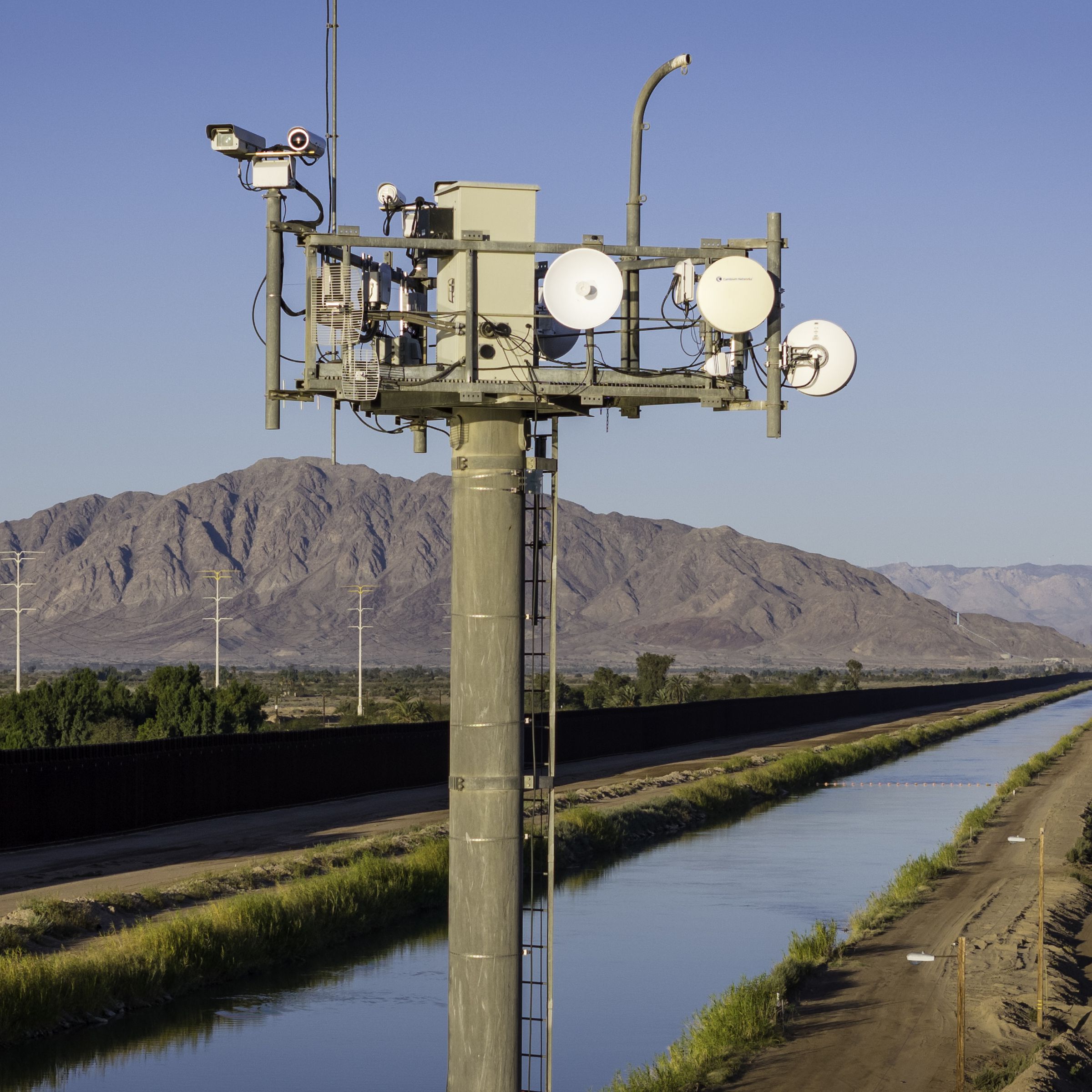 In an aerial view, cameras on a U.S. Customs and Border Protection (CBP) surveillance tower monitor activity along the U.S.-Mexico border fence and the All-American Canal on March 8, 2024 in Calexico, California