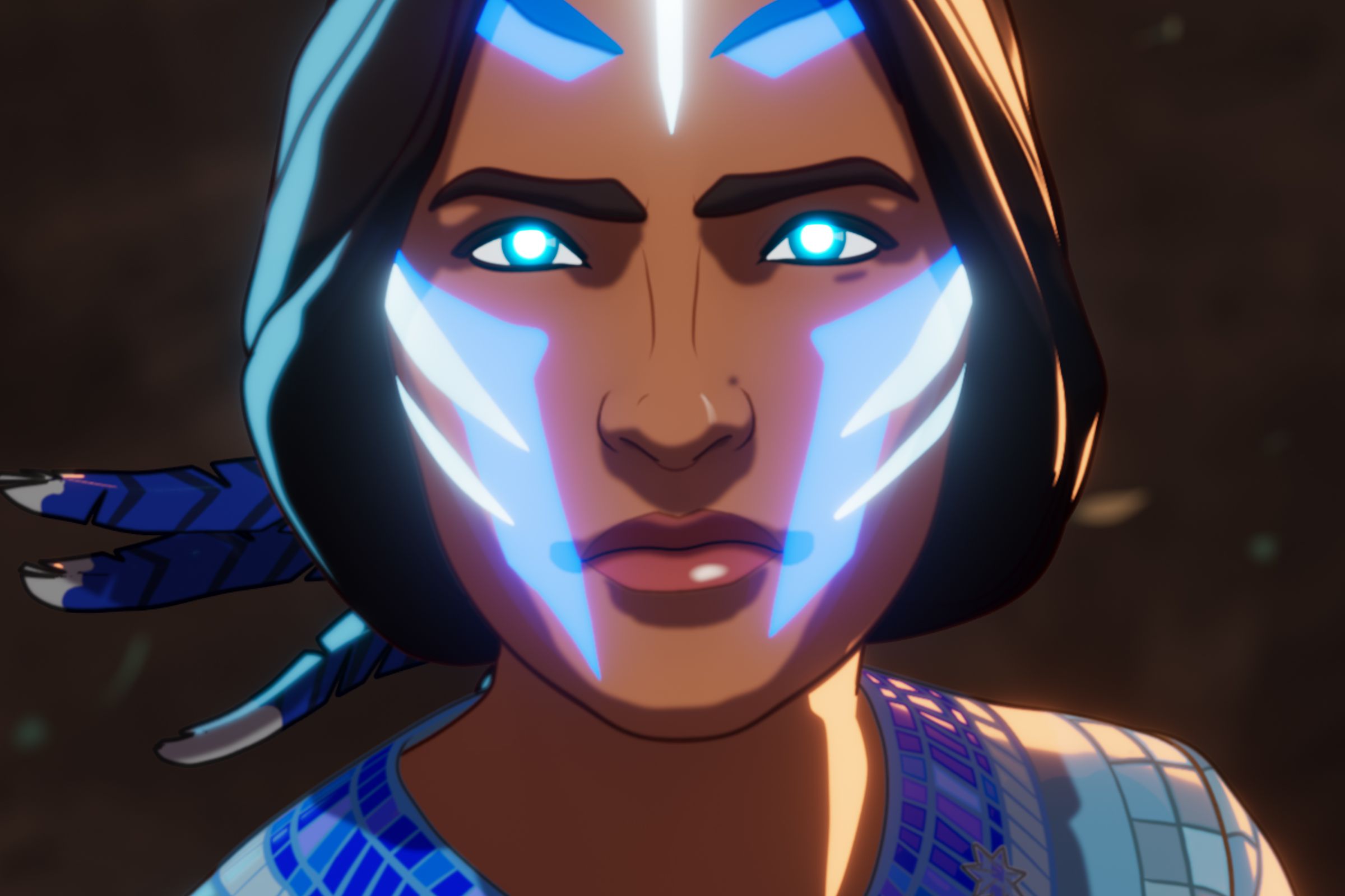 A tight shot of a young Native American woman whose face is adorned in glowing blue and white markings.