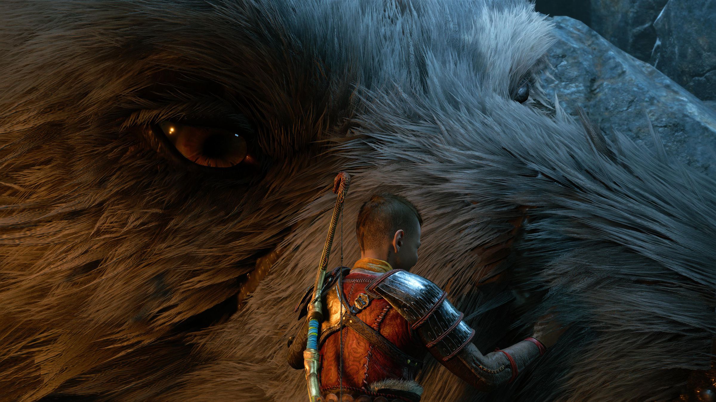 Screenshot from God of War Ragnarök in which Atreus is petting a giant wolf