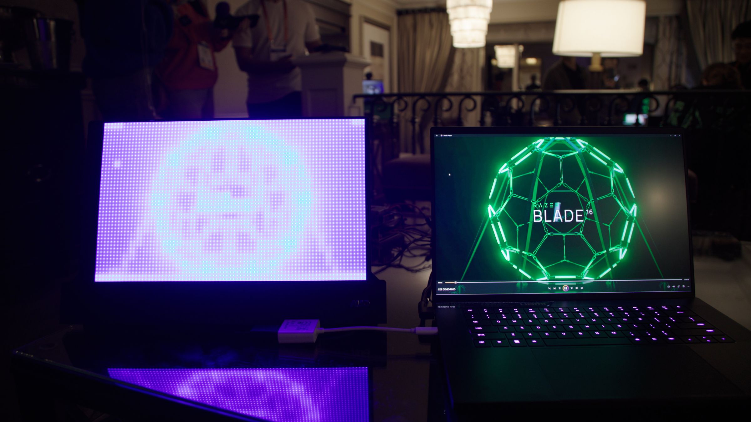 The Razer Blade 16 next to a mirroring panel of Mini LEDs displayed on a table.