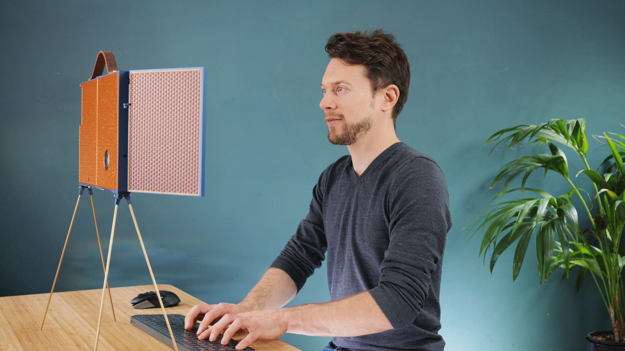 Foto del creador de marcos de bricolaje sentado frente a él, escribiendo con una postura suave.