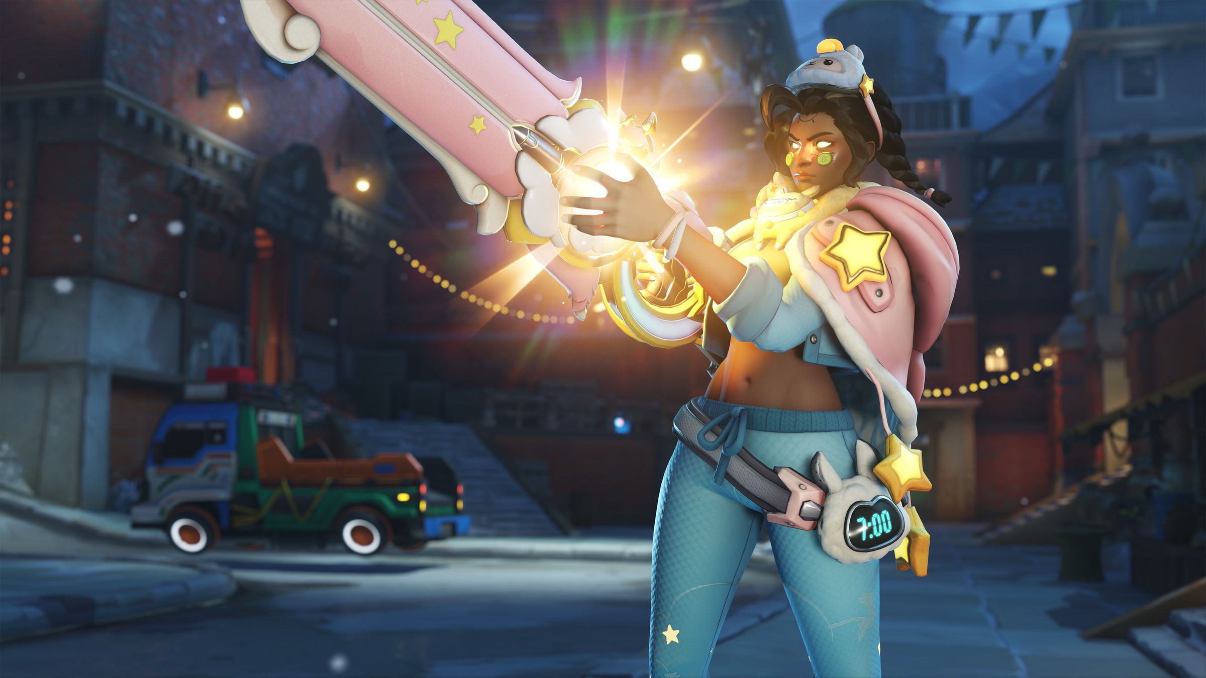 Screenshot from Overwatch 2 featuring Illari in her llama pajama skin featuring a blue and pink pastel color scheme, a llama sleep mask and blanket wrapped around her shoulders. A llama shaped alarm clock on her hip and star decals on her shoulders