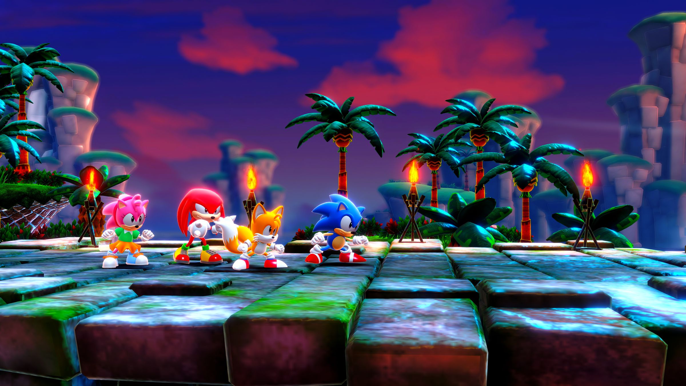 Screenshot from Sonic Frontiers featuring Amy, Knuckles, Tails and Sonic standing together in a tropical themed zone with lit tiki torches.