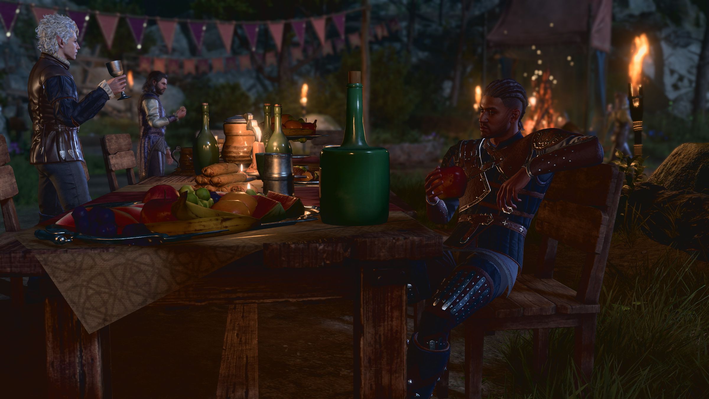 Screenshot from Baldur’s Gate 3 featuring the character Wyll in new camp clothes sitting at a table covered in food and wine for a feast while the character Astarion holds a goblet of wine in the background.