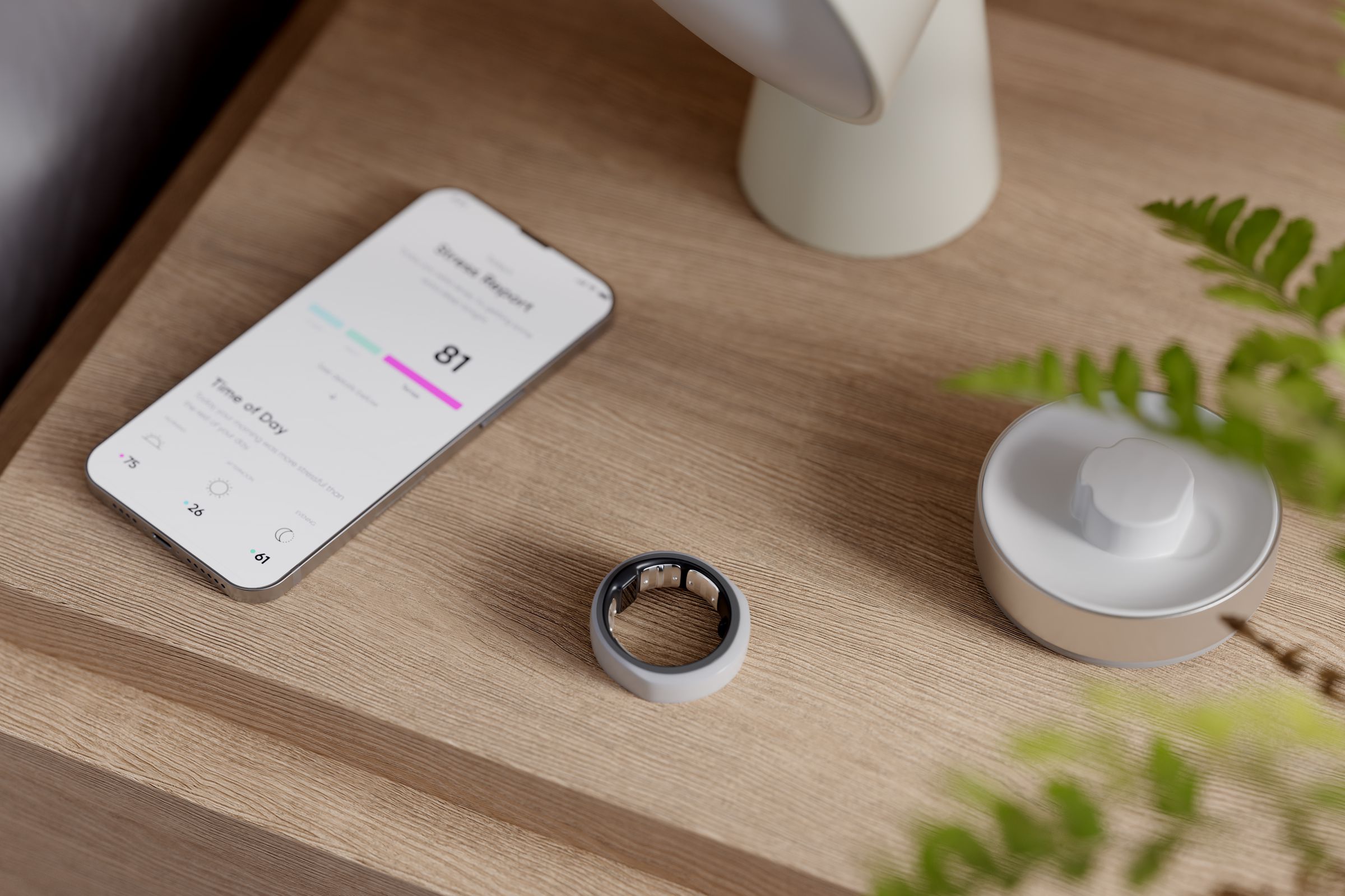 Gray smart ring on a table with a phone