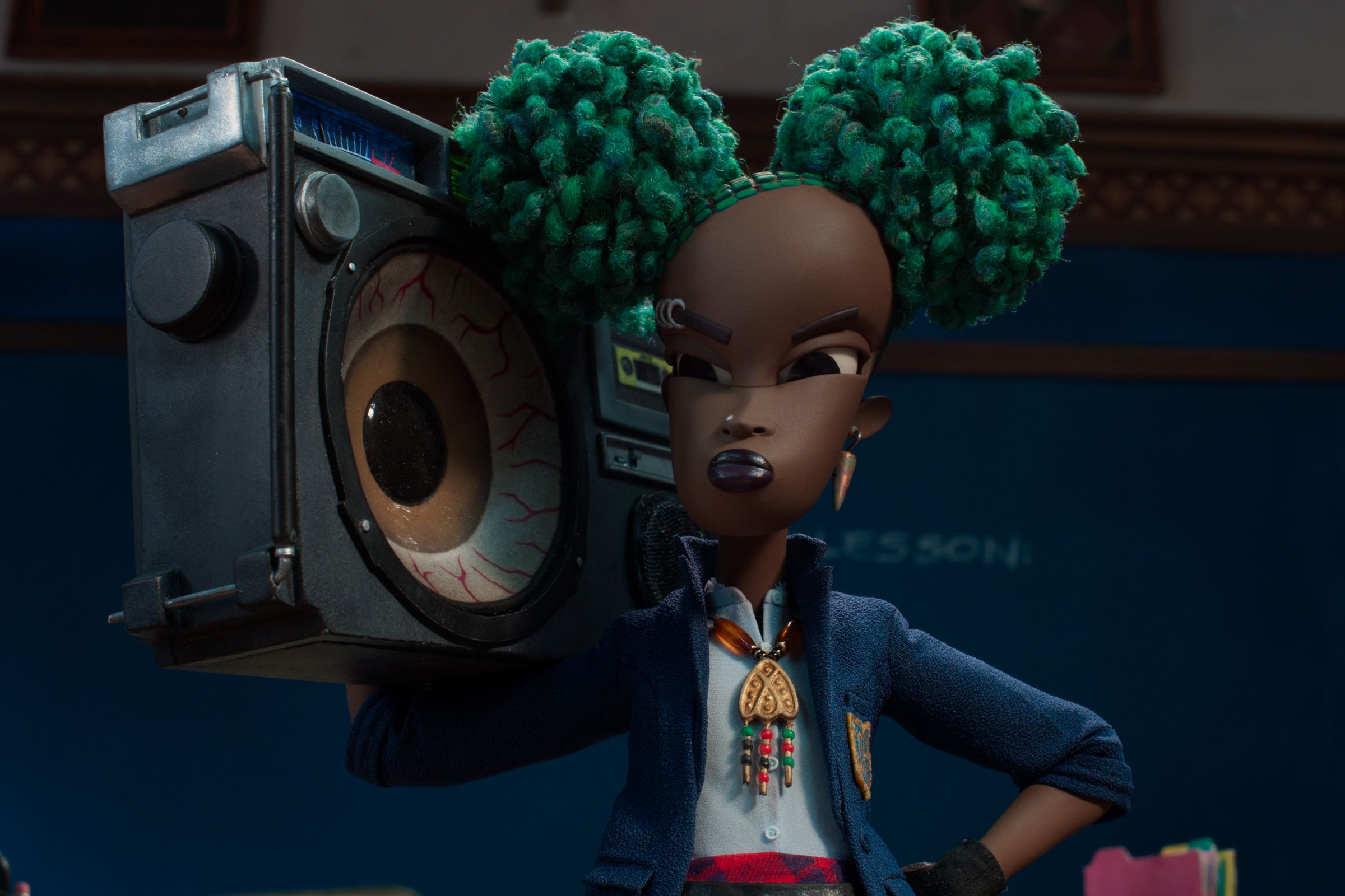 A girl with neon green afro puffs wearing a school blazer and carrying a boombox with a speaker that appears to be an eyeball. The girl is scowling and standing in front of a chalkboard.