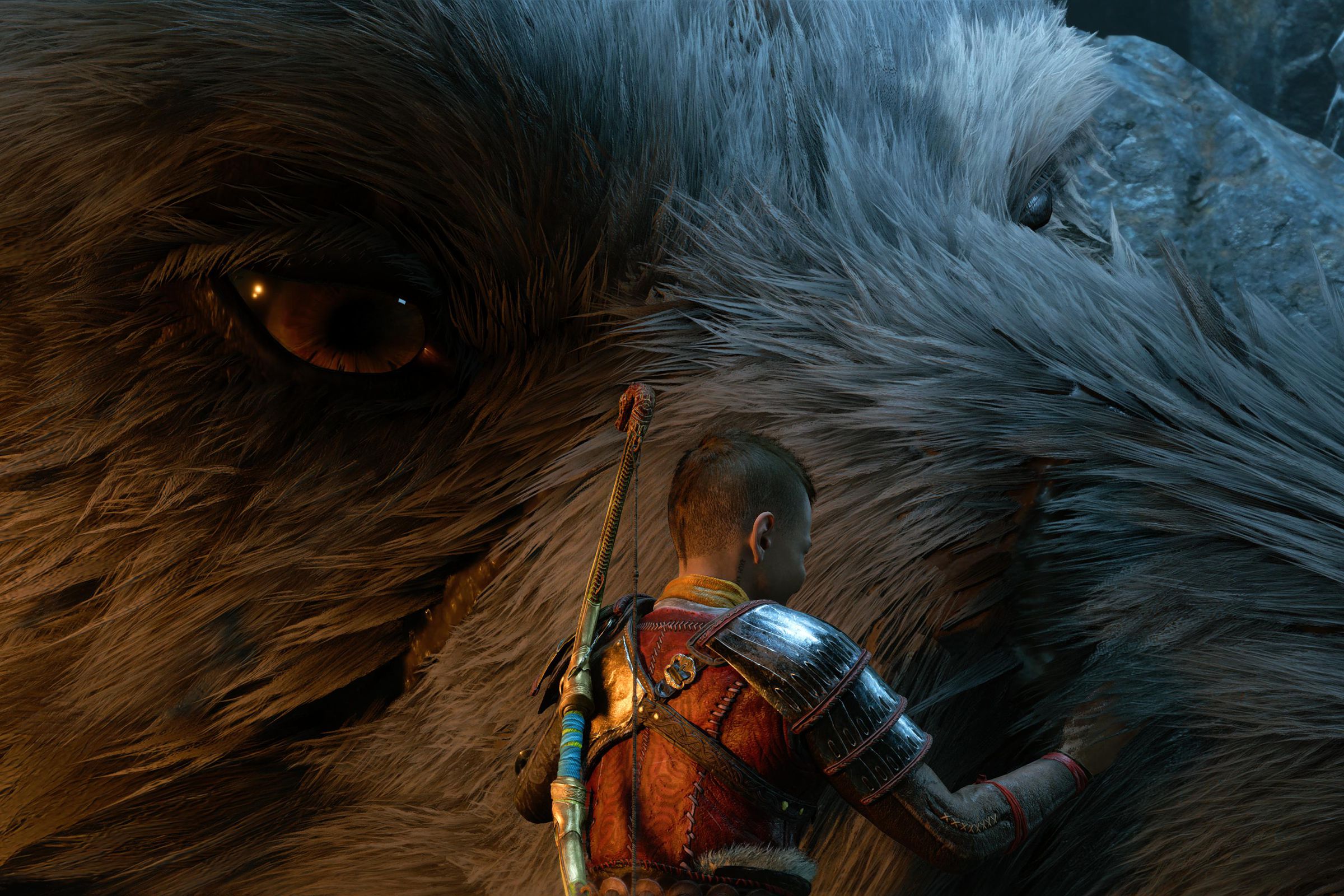 Screenshot from God of War Ragnarök in which Atreus is petting a giant wolf