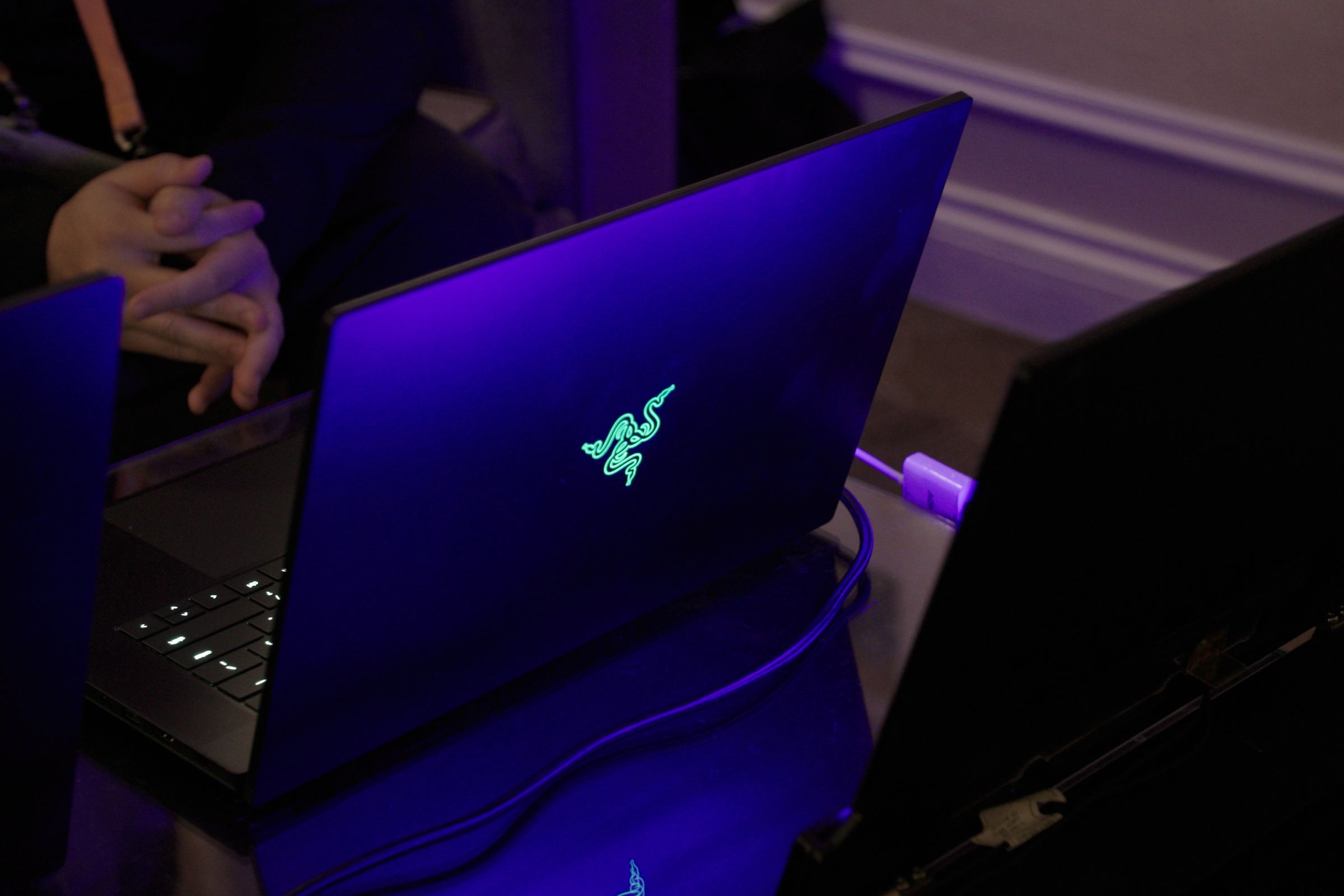 The Razer Blade 16 seen from the back on a dark table.