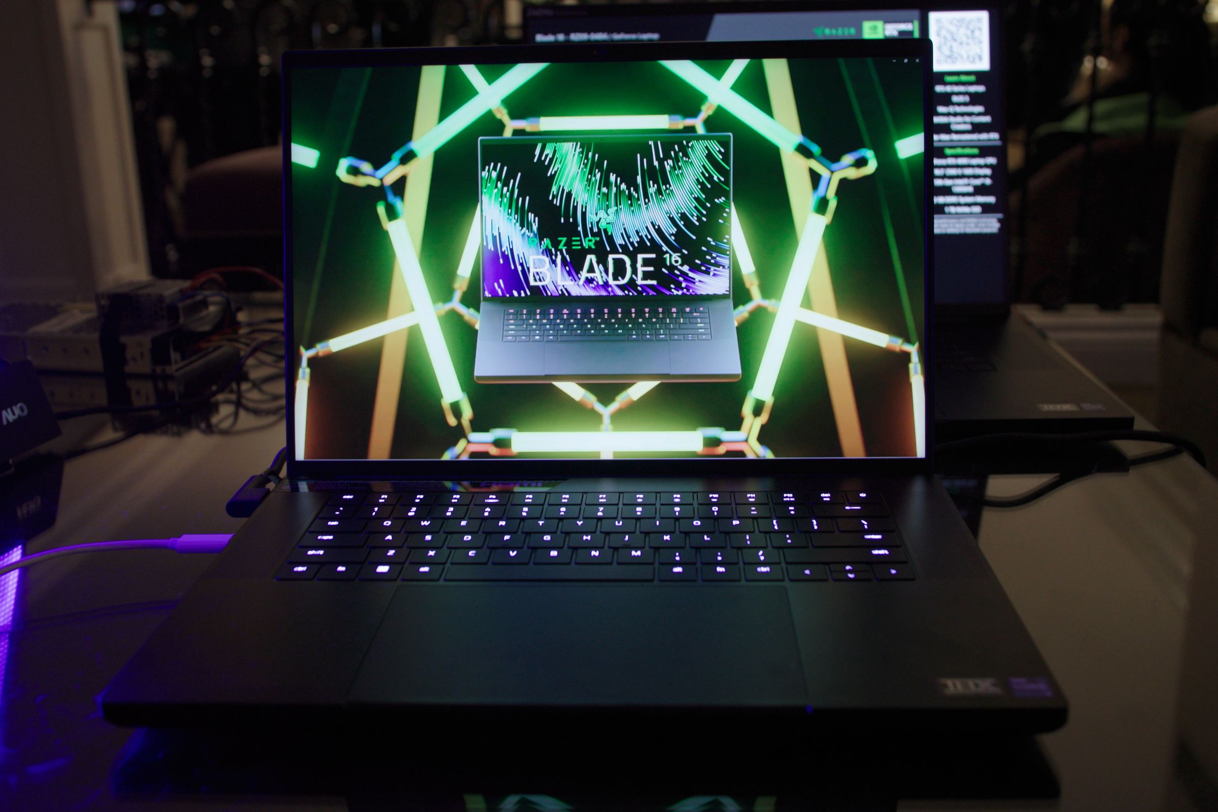 The Razer Blade 16 displaying a picture of itself over a neon grid.