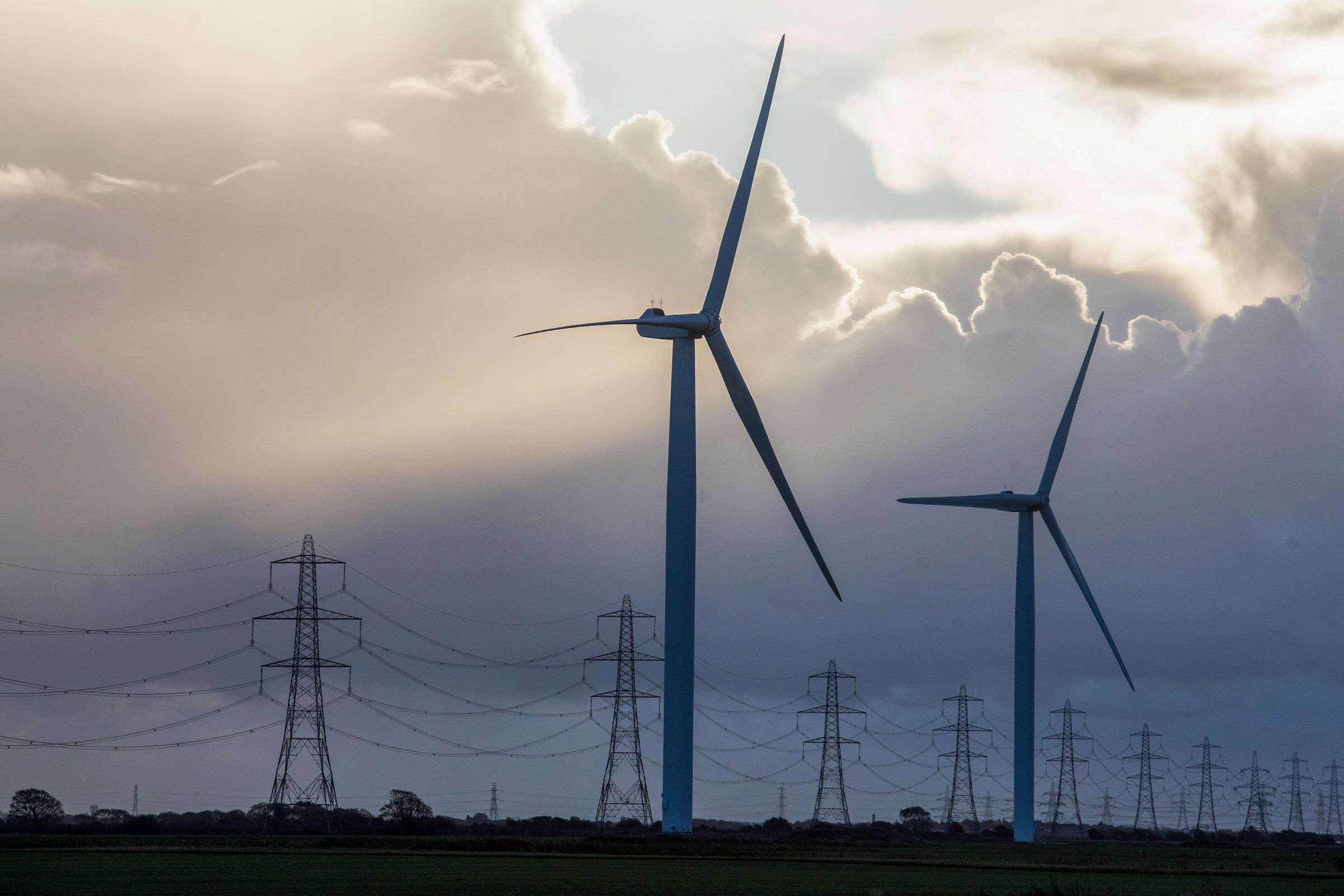 Onshore wind turbines and electricity transmission pylons at the Little Cheyne Court Wind Farm near Camber, U.K., on Monday, Oct. 26, 2020.&nbsp;