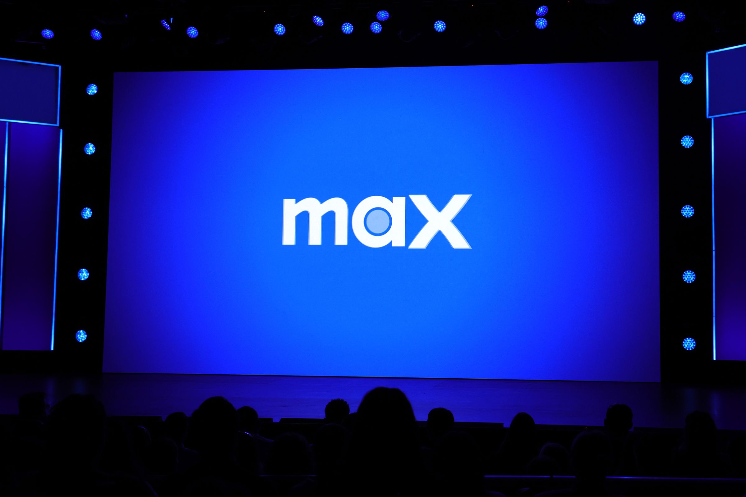 The Max logo being displayed on a massive screen before an audience.