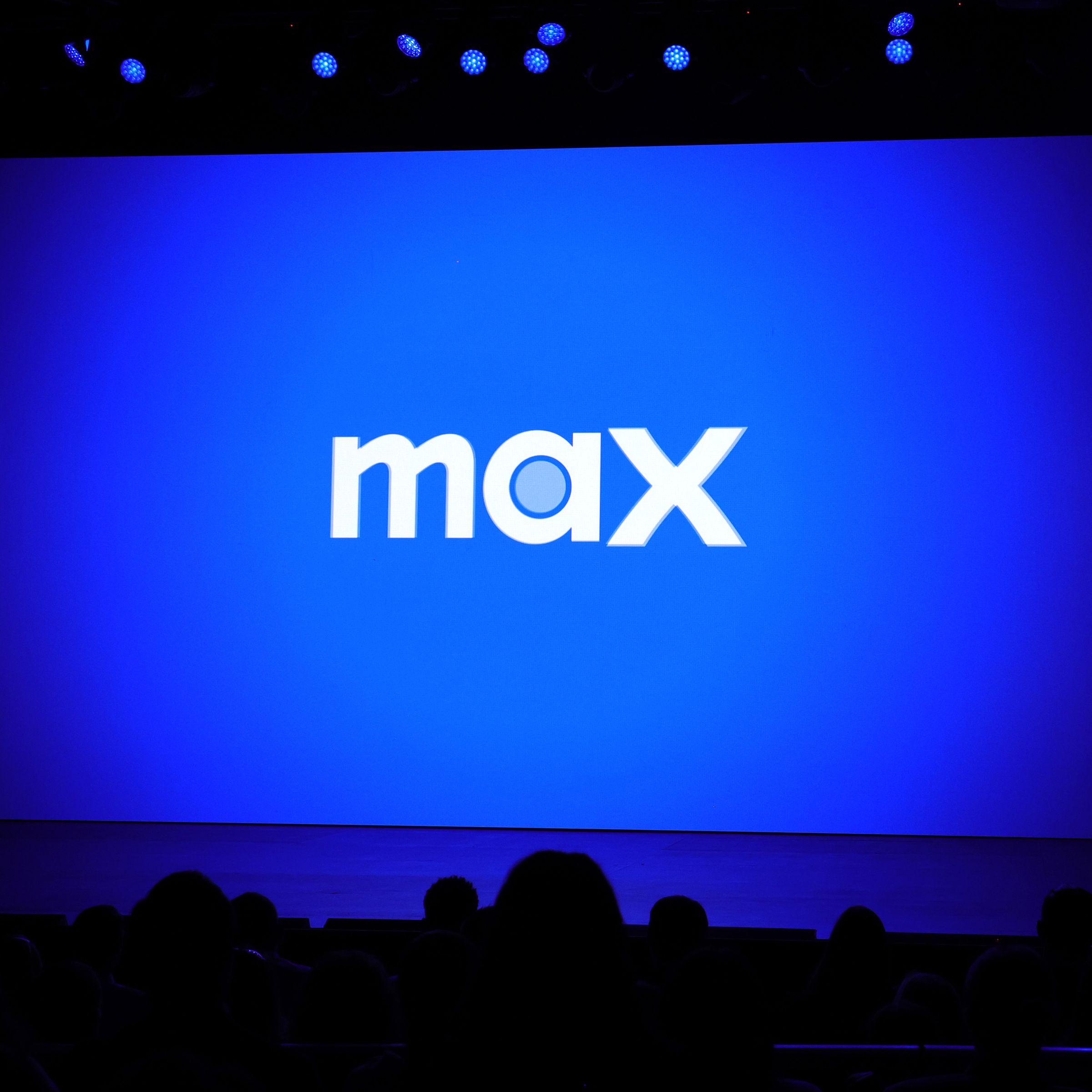 The Max logo being displayed on a massive screen before an audience.