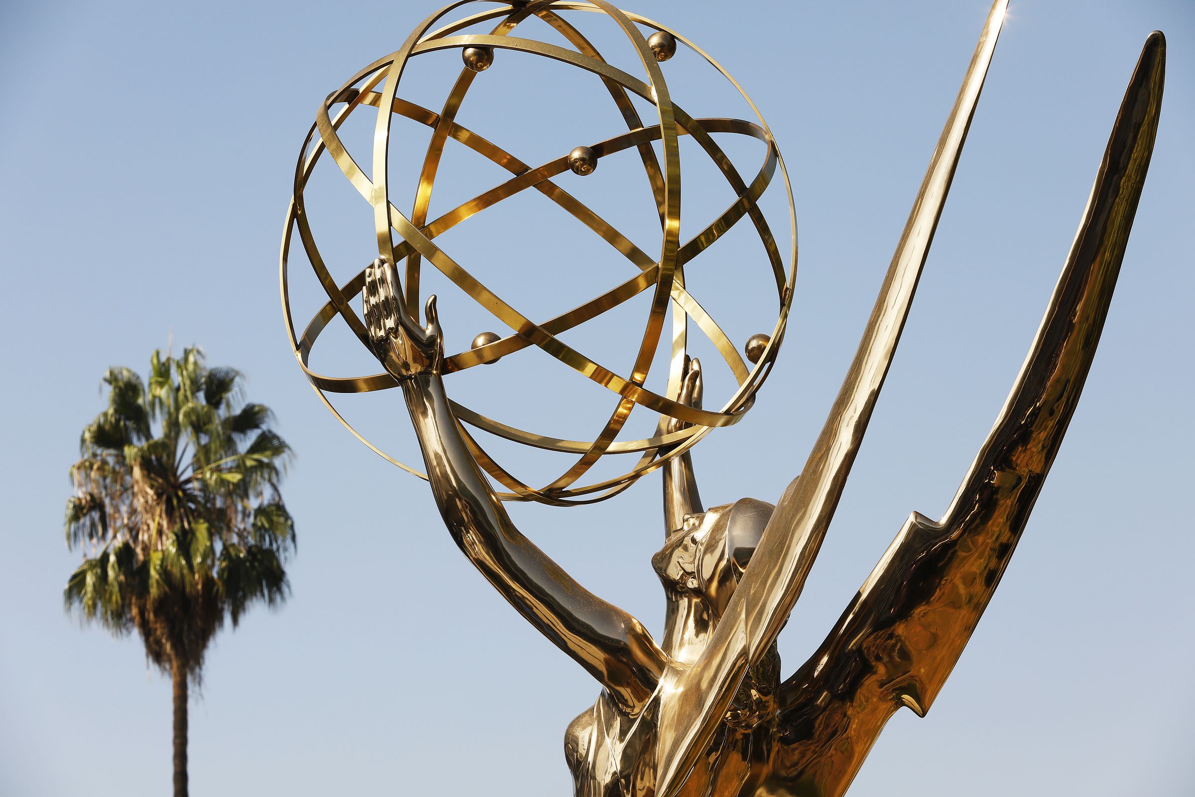 A photo showing the Emmy Awards statue next to a palm tree