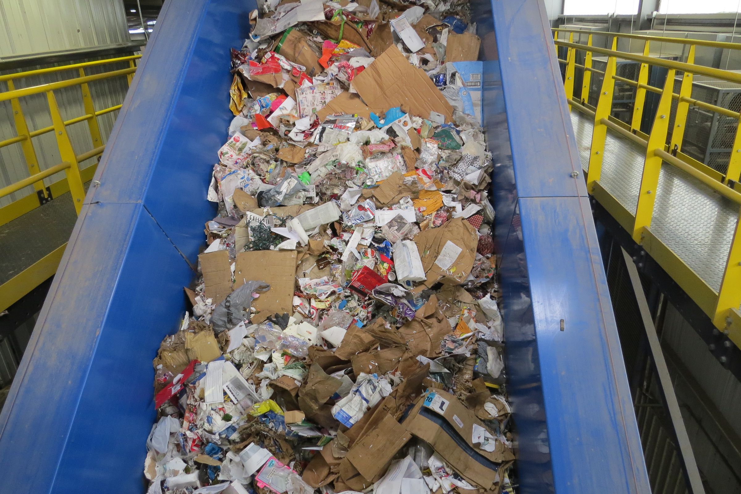 Unsorted recycling rides up a conveyor belt at a processing plant in Plano, Texas.