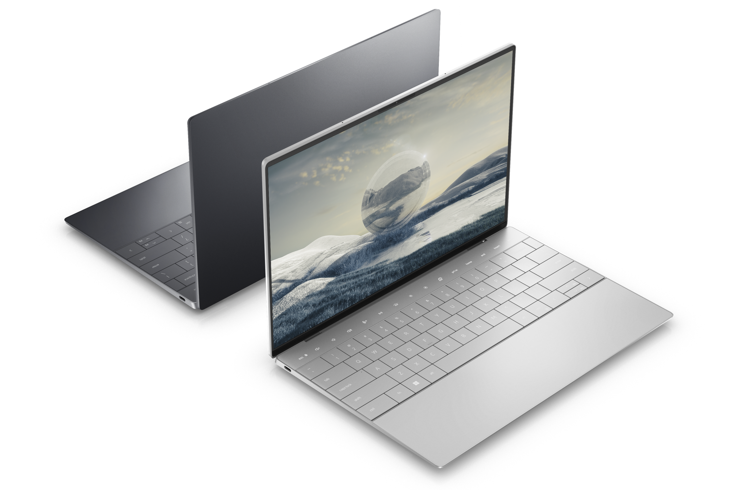 Two Dell XPS 13 Plus models open, displayed back to back on a white background. The front model, facing the camera, is platinum, displaying a mountainous desktop background. The back model is graphite.