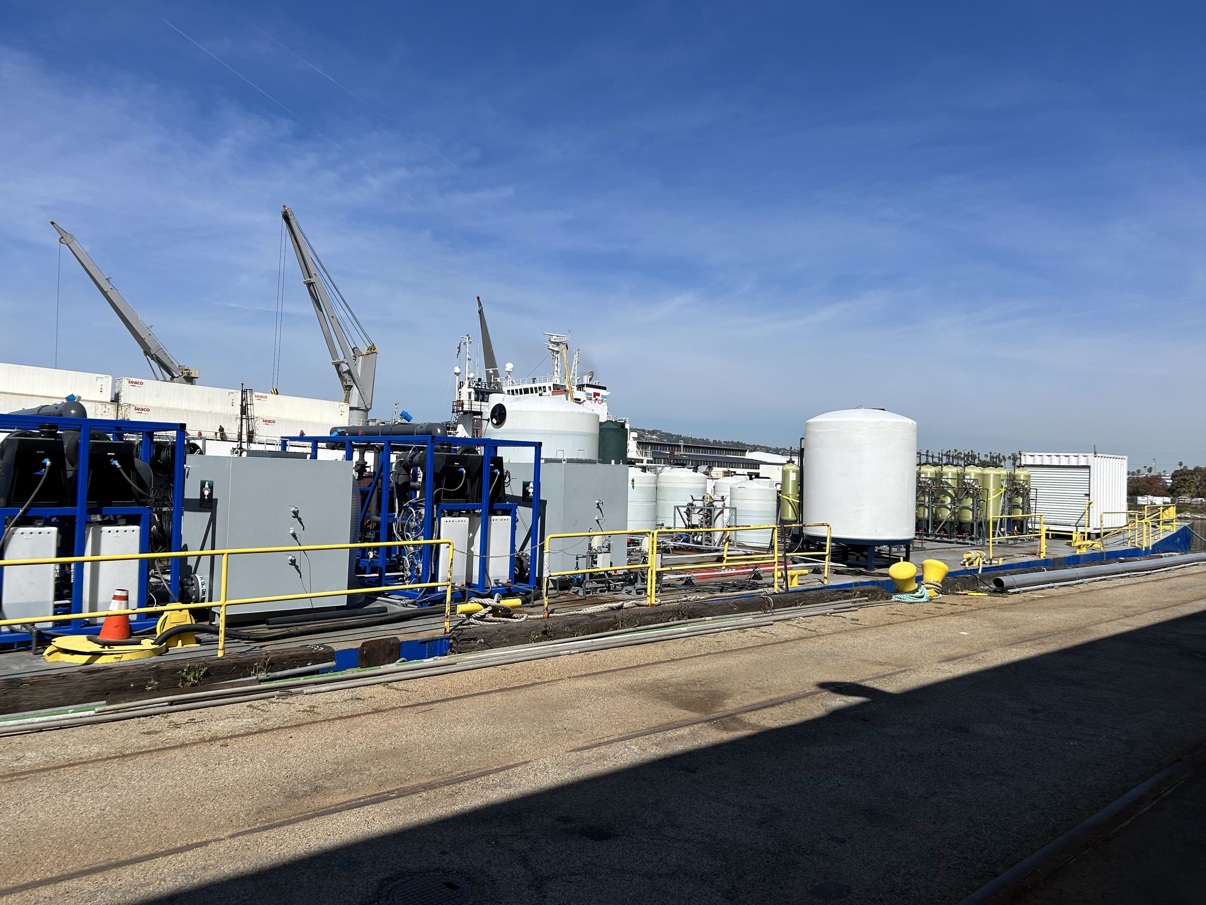 Wide view of an industrial facility with large white water tanks.