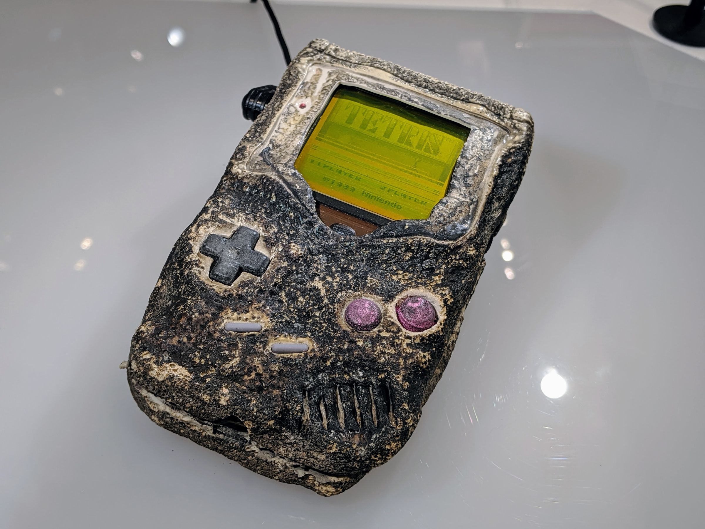 The top of the game boy is quite black with charring but Tetris is visible on the screen.