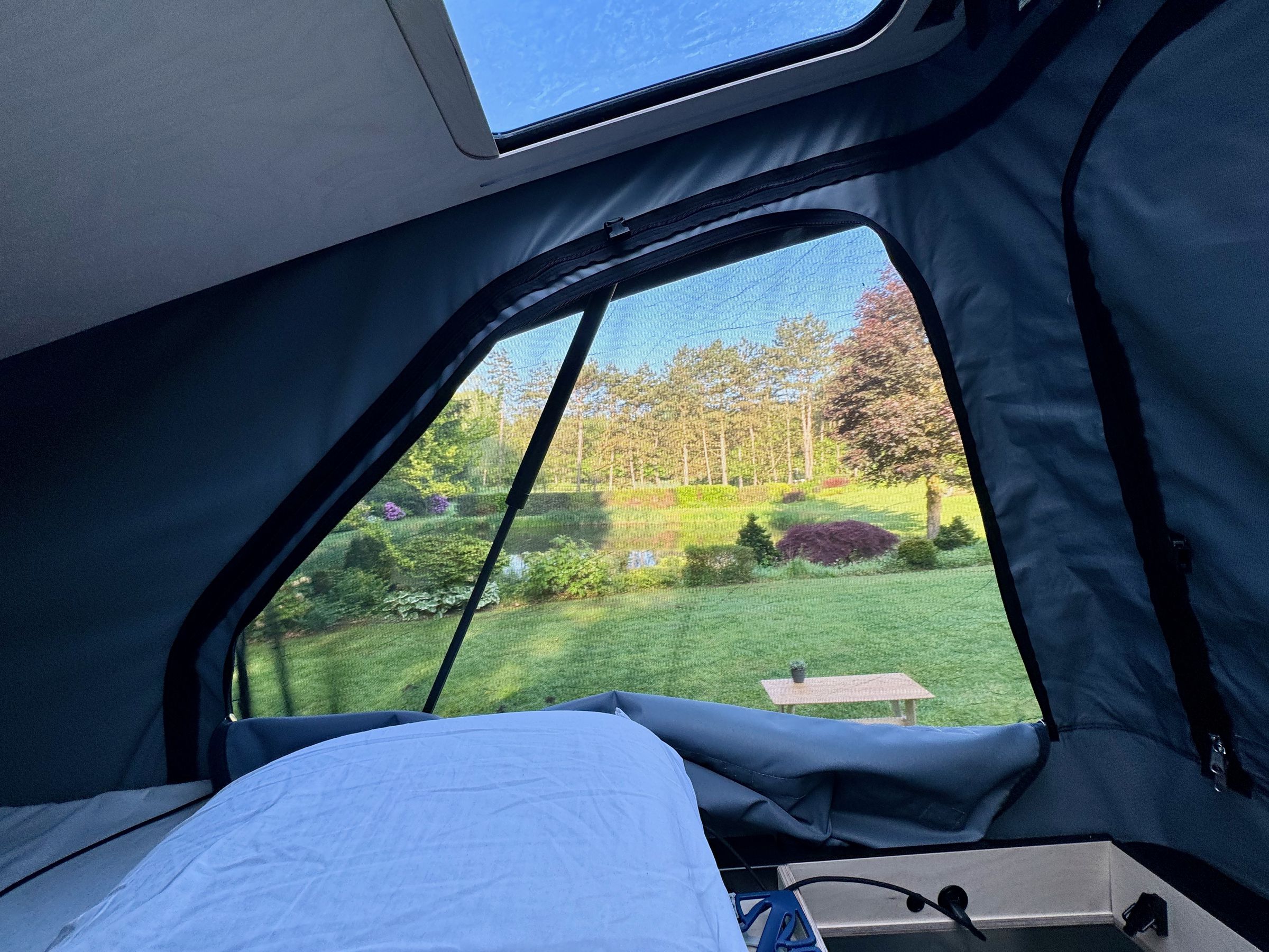 <em>The three zipped panels around the pop-top tent unzip to open completely, or with a bug net, or close completely to lock out the light. Also visible (lower right) are two USB jacks and a dimmer.</em>