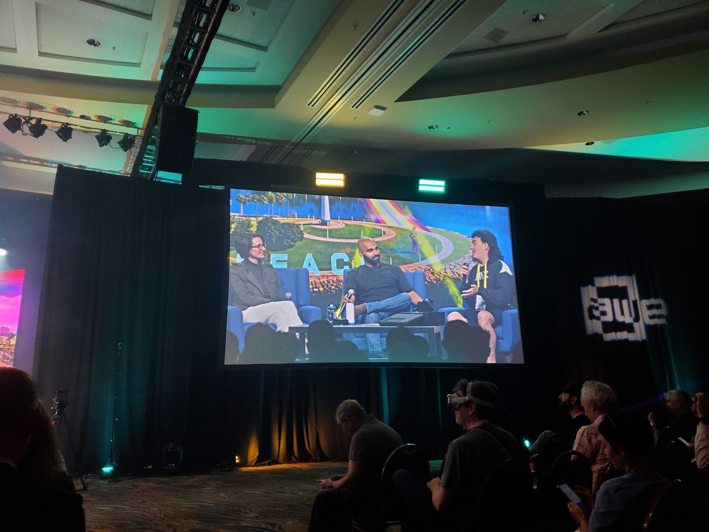 An image of Palmer Luckey and Darshan Shankar with their respective headsets (the DK1 and Bigscreen Beyond) on a panel talk.
