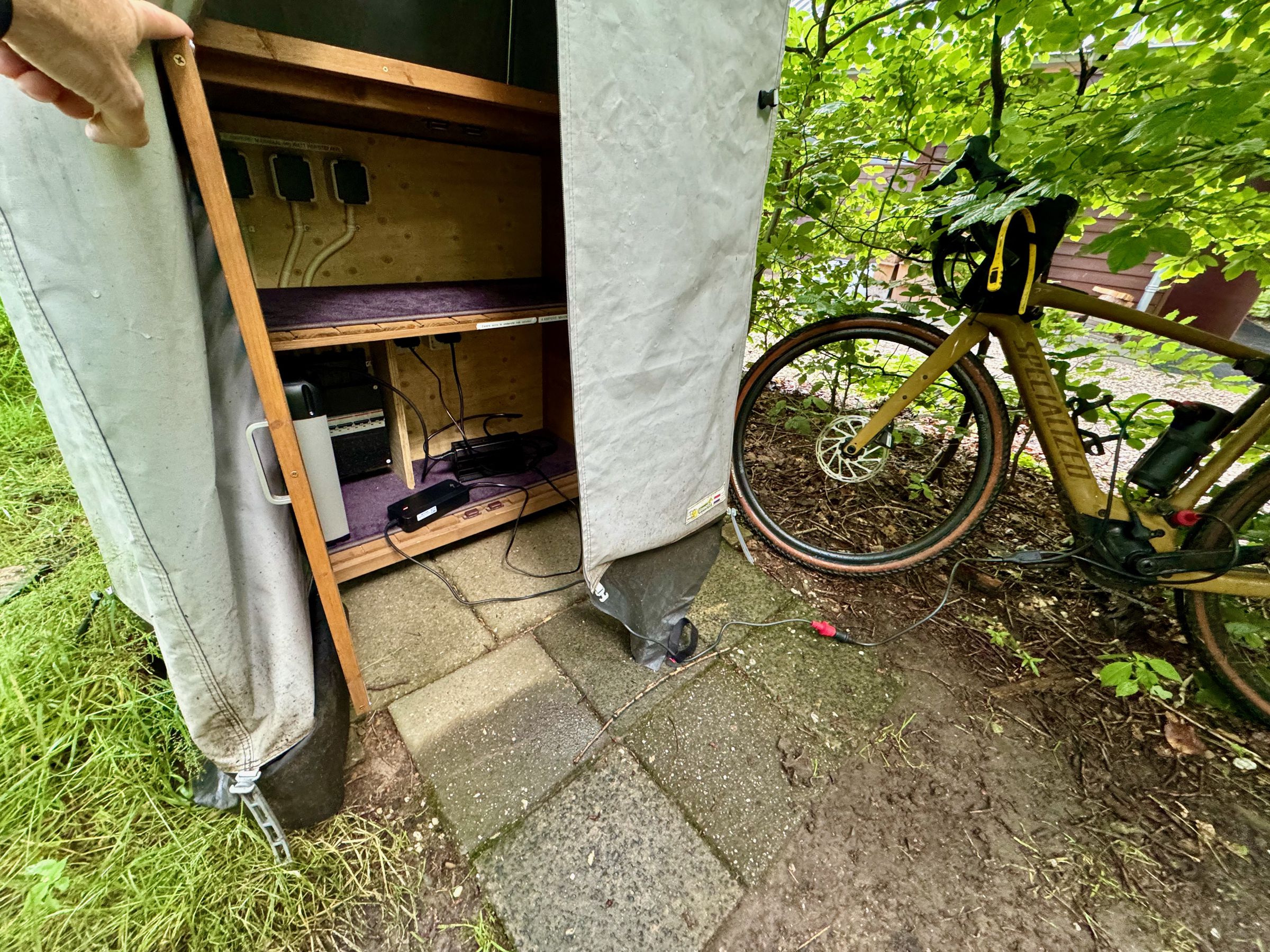 <em>This campsite offered this solar tent to charge e-bike batteries, assuming they’re removable. The main battery in the Specialized Turbo Creo 2 Comp is integrated, however, so I had to leave it here — about 200 meters from my tent — charging with the Y-cable overnight and in the rain, with nothing but a small lock, trash bag, and luck to protect it.</em>