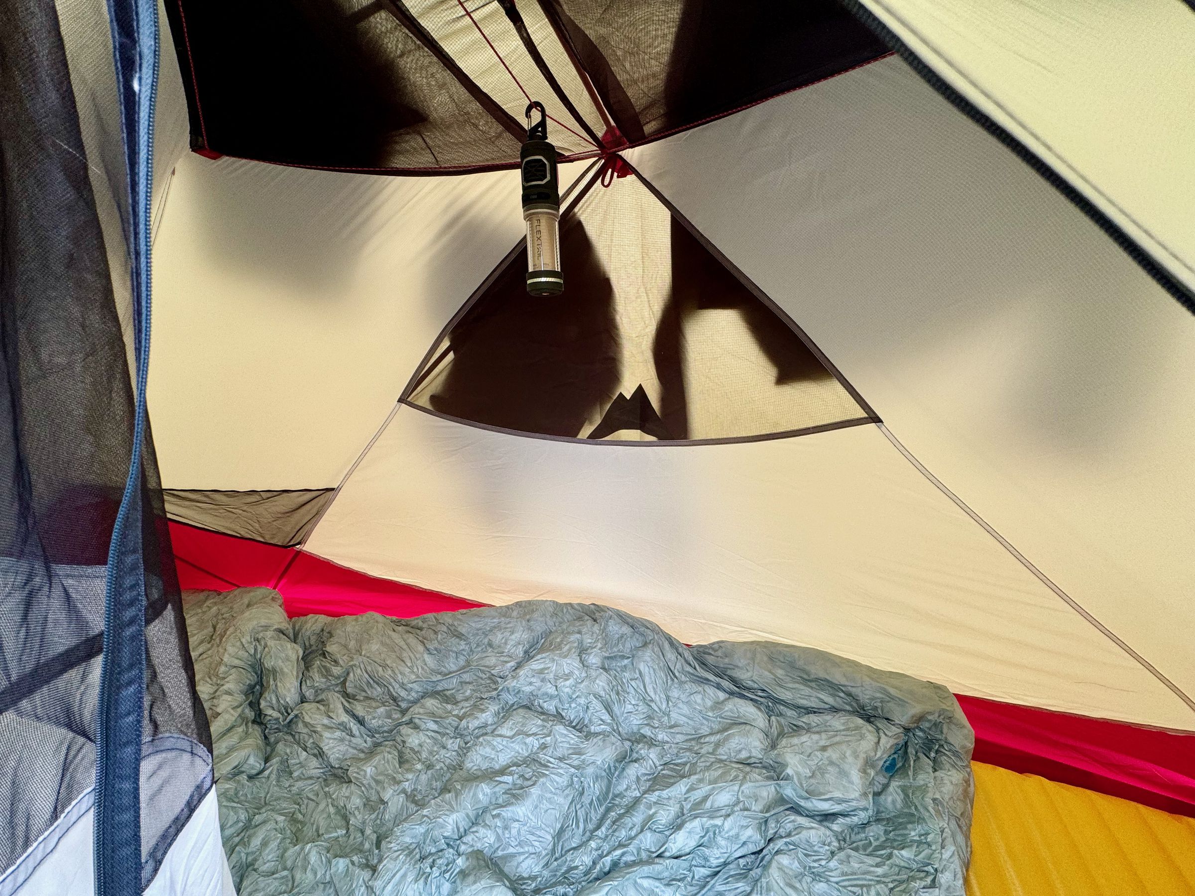 <em>You can see the clotheslines and a corner pocket on the left. The Thermarest sleeping pad and quilt fit nicely inside without being too cramped. A Flextail Tiny Repeller S combo bug repeller and lamp is hanging from the clothesline.</em>
