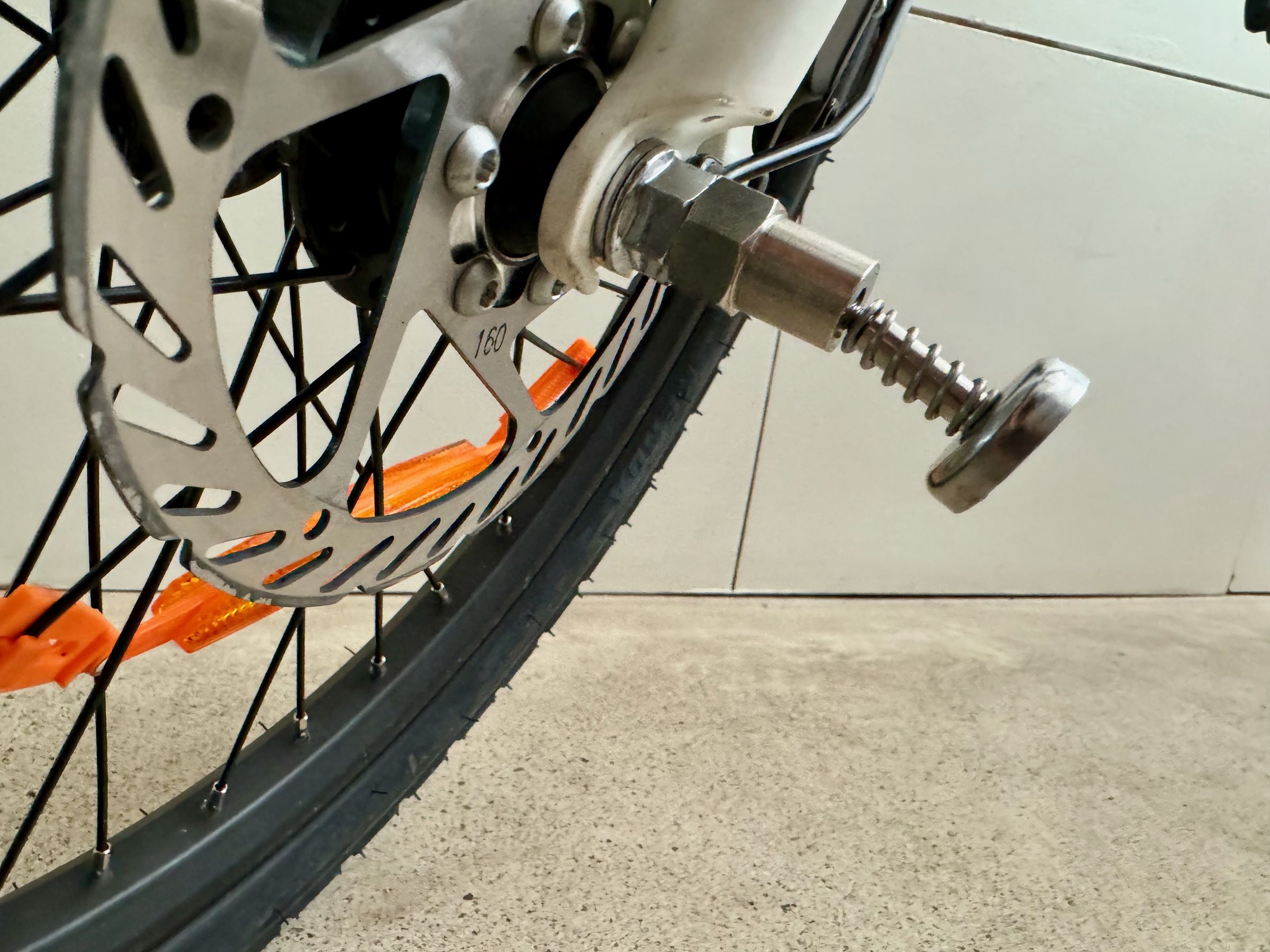 <em>This little magnet protrusion attaches to the front axel and helps ensure the folded e-bike stays folded. It rattles when riding on uneven surfaces. I took mine off after a few days, but I didn’t need to fold it often.</em>