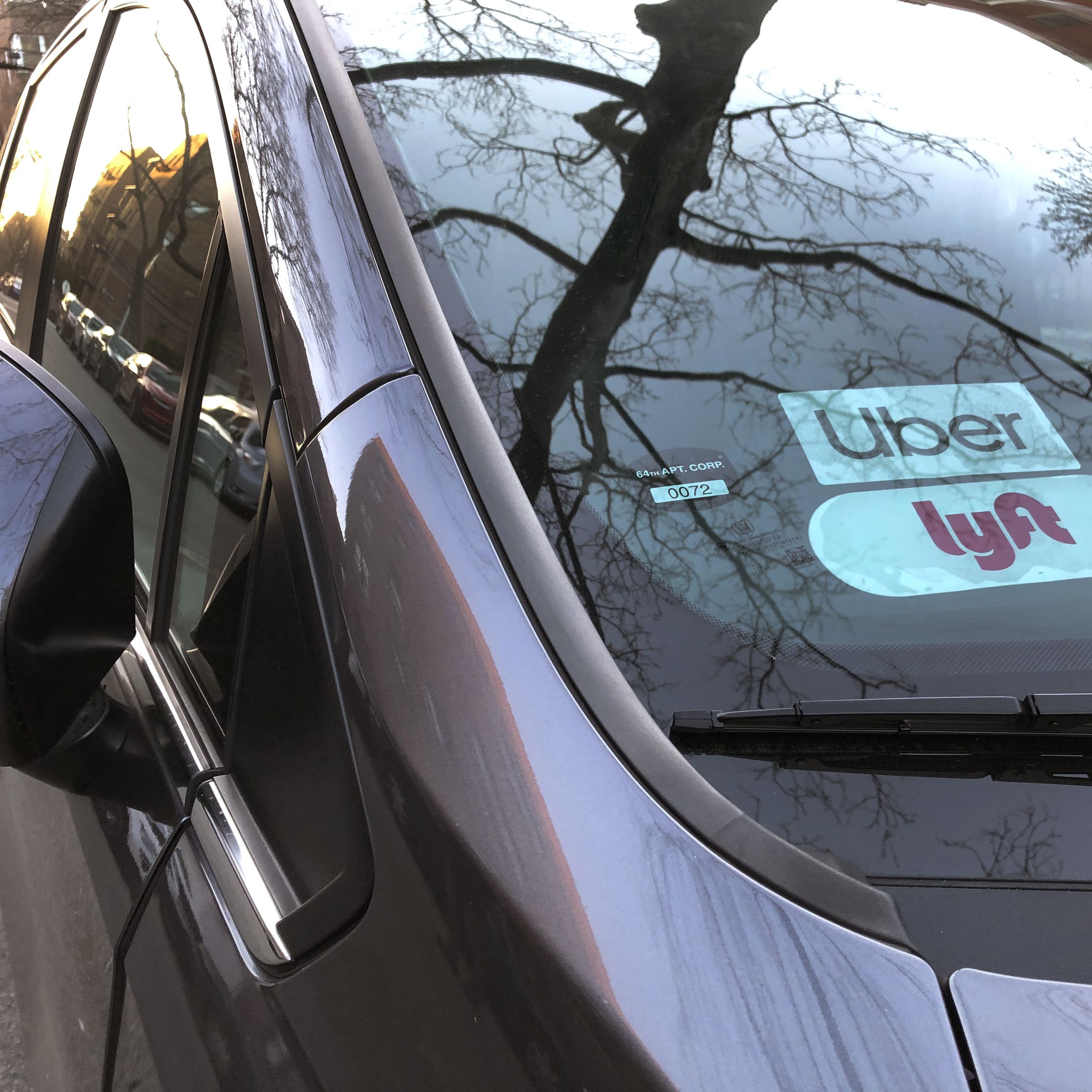 Uber and Lyft sign in windshield of car, Queens, New York