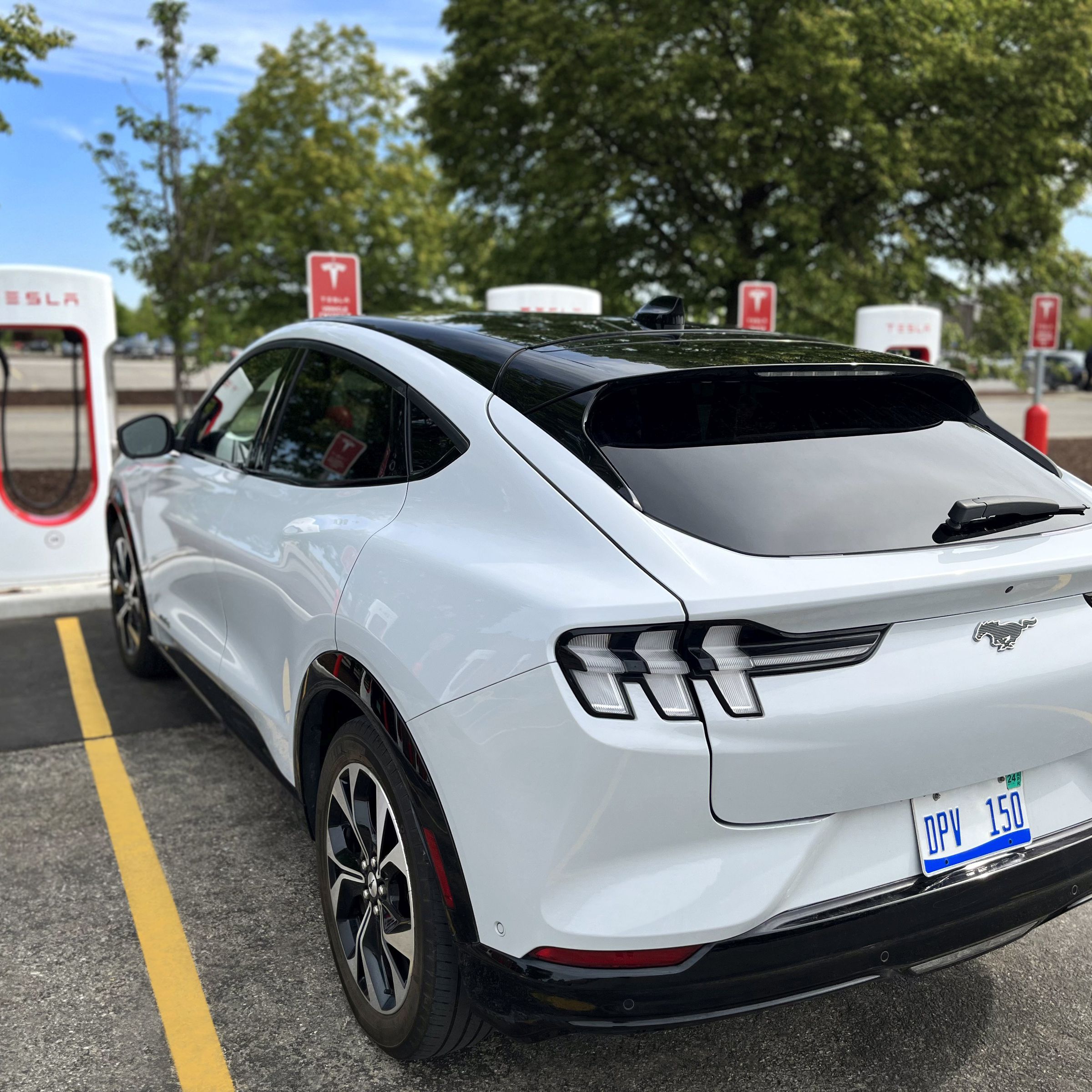 A Ford Mustang Mach-E sitting at a Tesla Supercharger