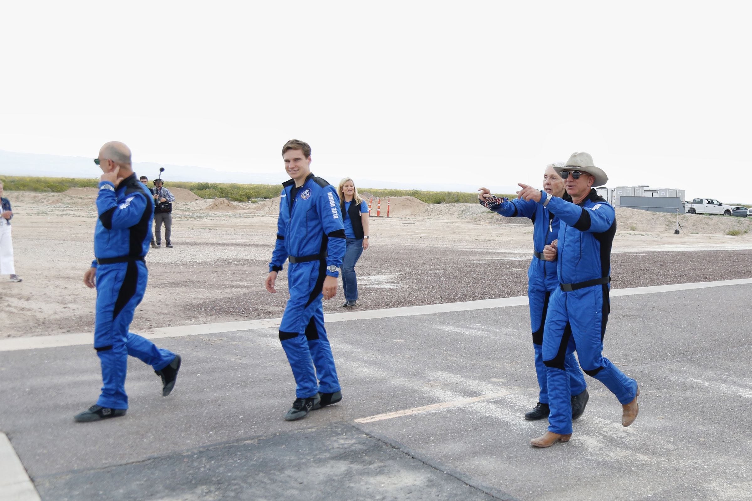 (Left to right) Mark Bezos, Oliver Daemen, Wally Funk and Jeff Bezos walk toward New Shepard’s landing pad for a photo opp hours after returning from a quick trip to space.
