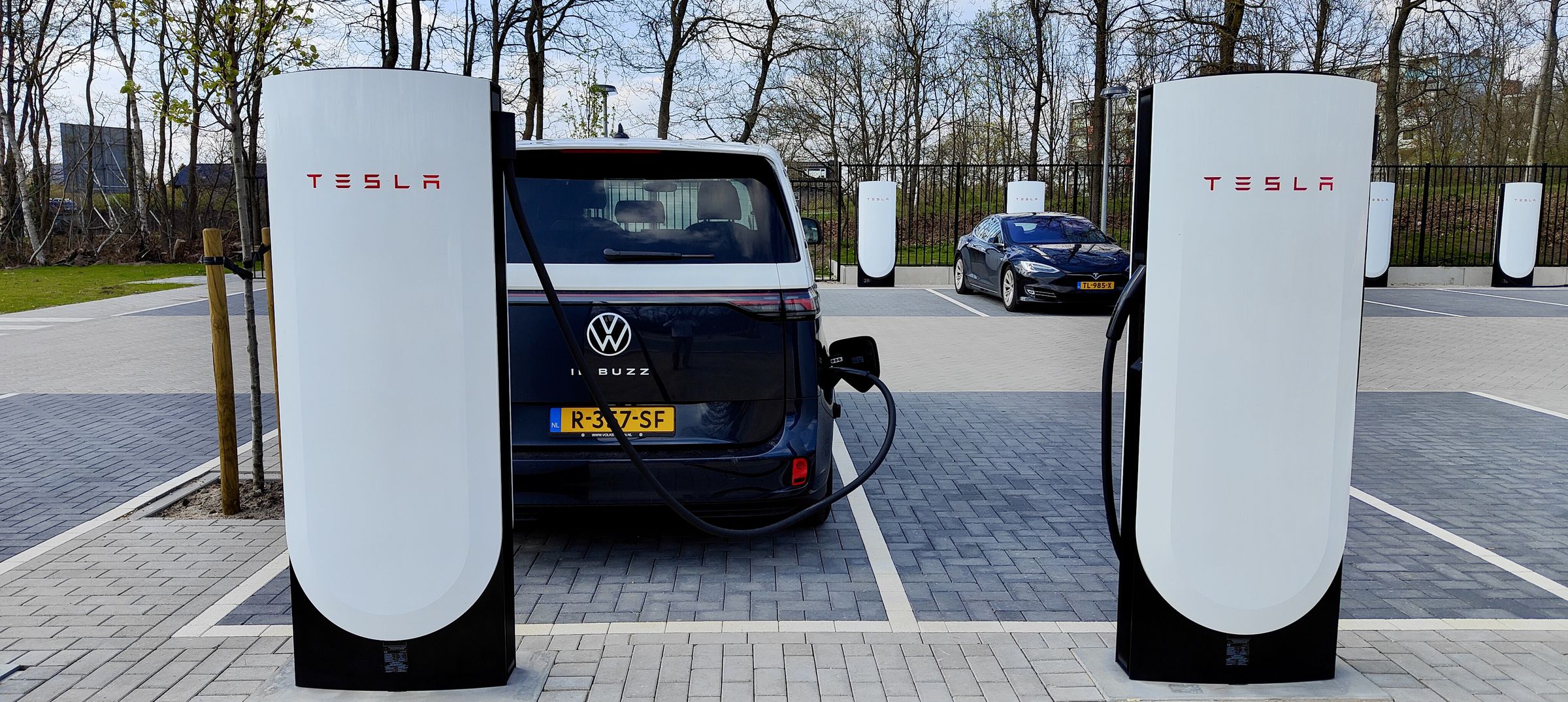 Yes, Tesla’s chargers, like this V4 Supercharger in the Netherlands, are generally open to all comers in Europe, no adapter needed since even Teslas come standard with CCS charging ports.