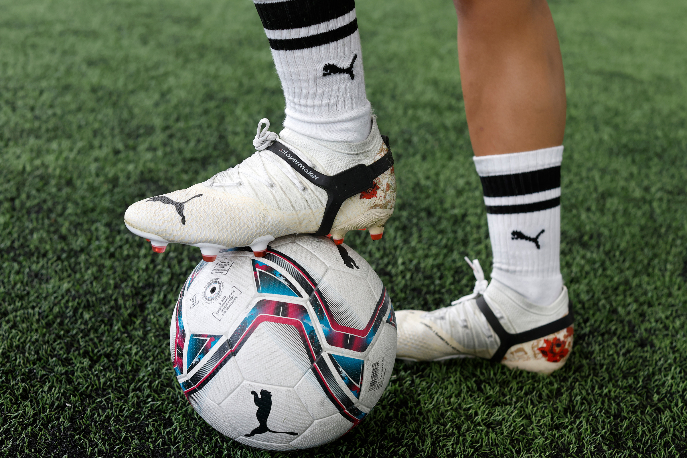 Futbol topunu durdururken bir kişinin kramponlarında CITYPLAY takipçisi