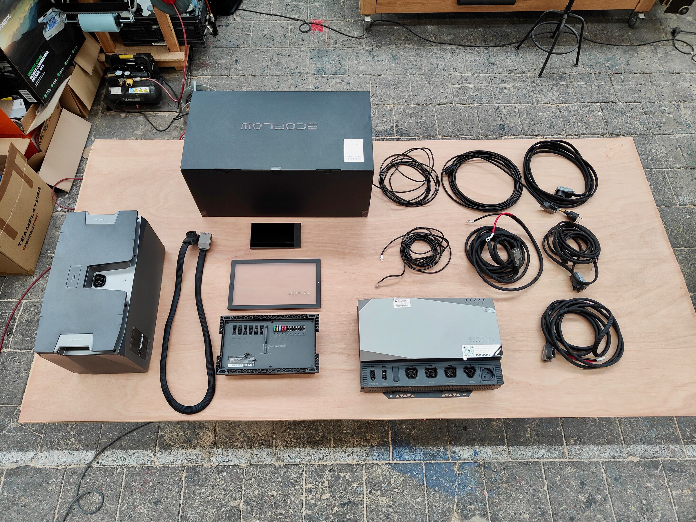The EcoFlow Power Kit. From left to right: one 5kWh battery, the battery cable, and the Power Kit box. Below the box is the console display and AC/DC Smart Distribution Panel and cover. Then you see the included Power Hub cabling, and the Power Hub itself.