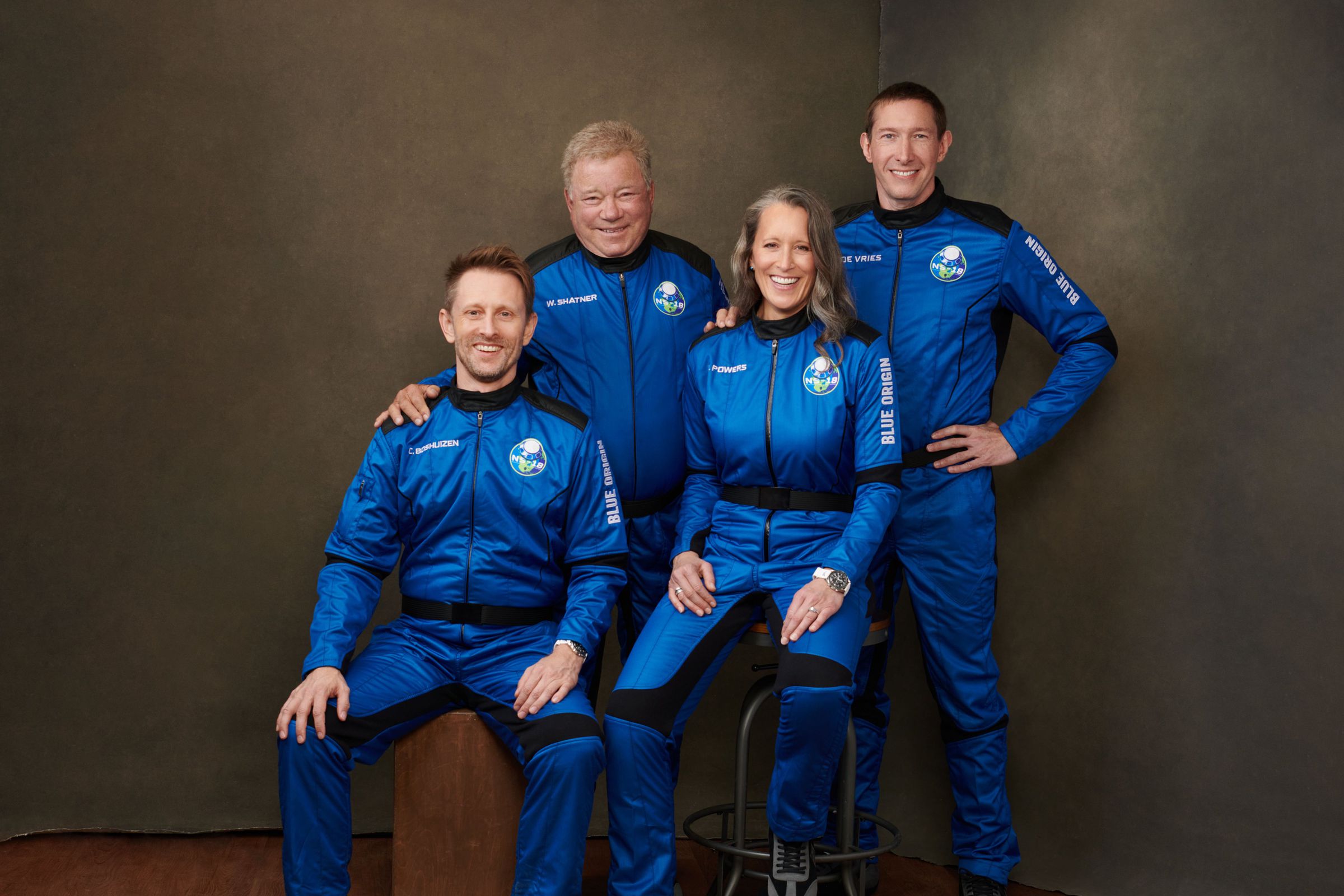 William Shatner and his fellow passengers pose in their Blue Origin flight suits