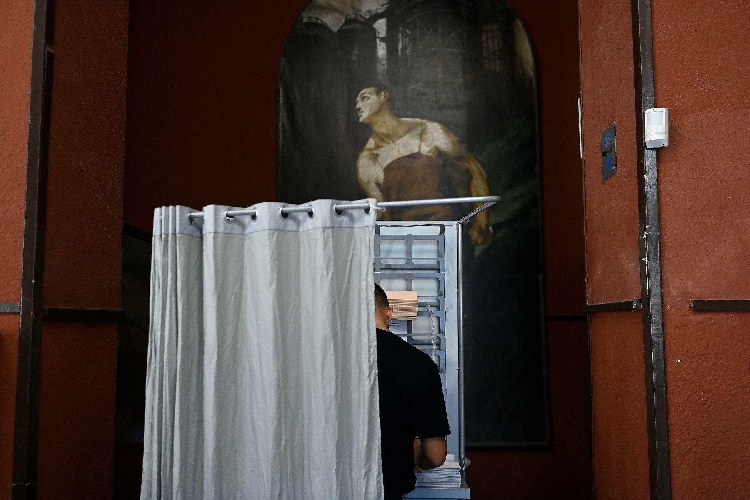 A person votes in a booth at the Rios Rosas polling station in Madrid during Spain’s general election on July 23rd, 2023.