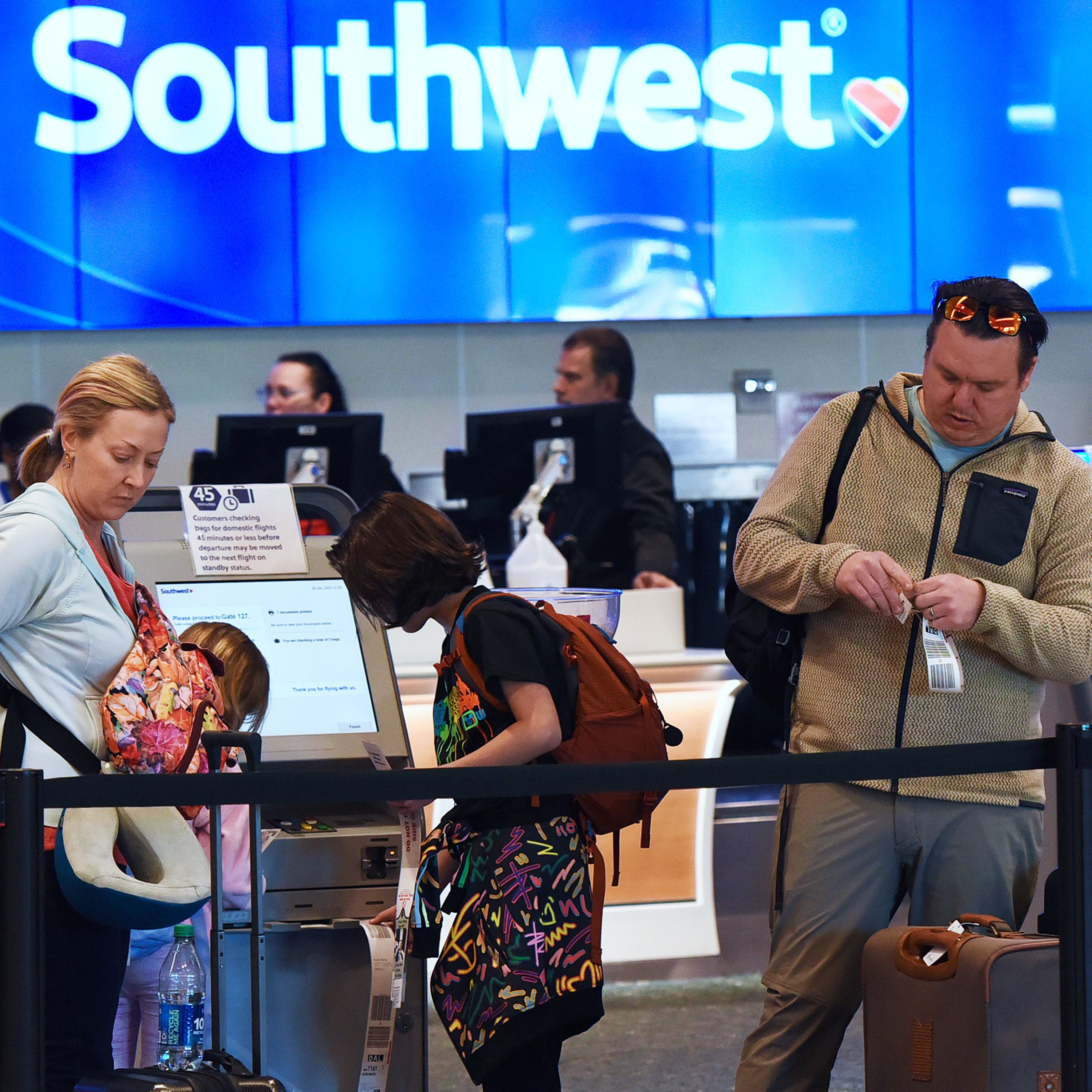 An image showing passengers in front of a Southwest Airlines kiosk at an airport