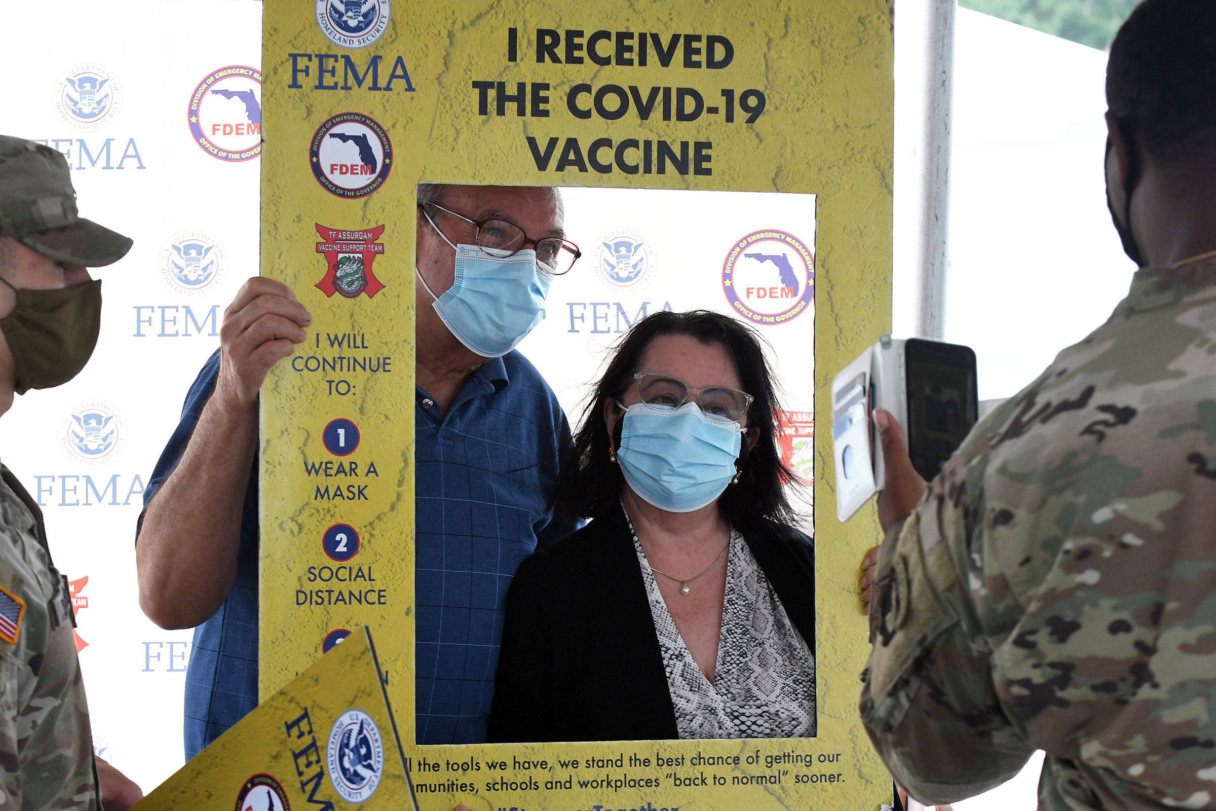 People pose for a photo after being vaccinated at the FEMA-...