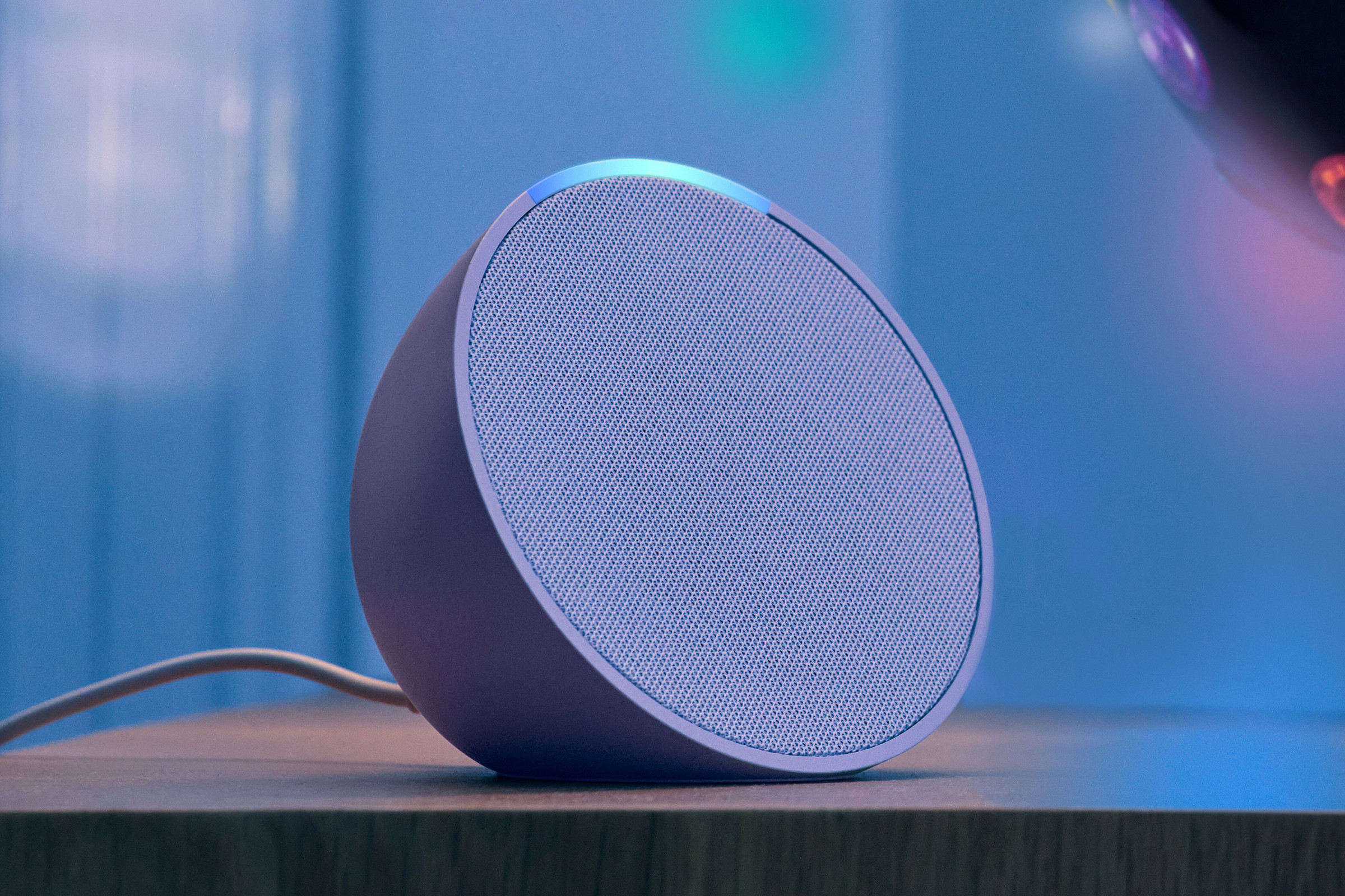 A purple speaker on a desk.