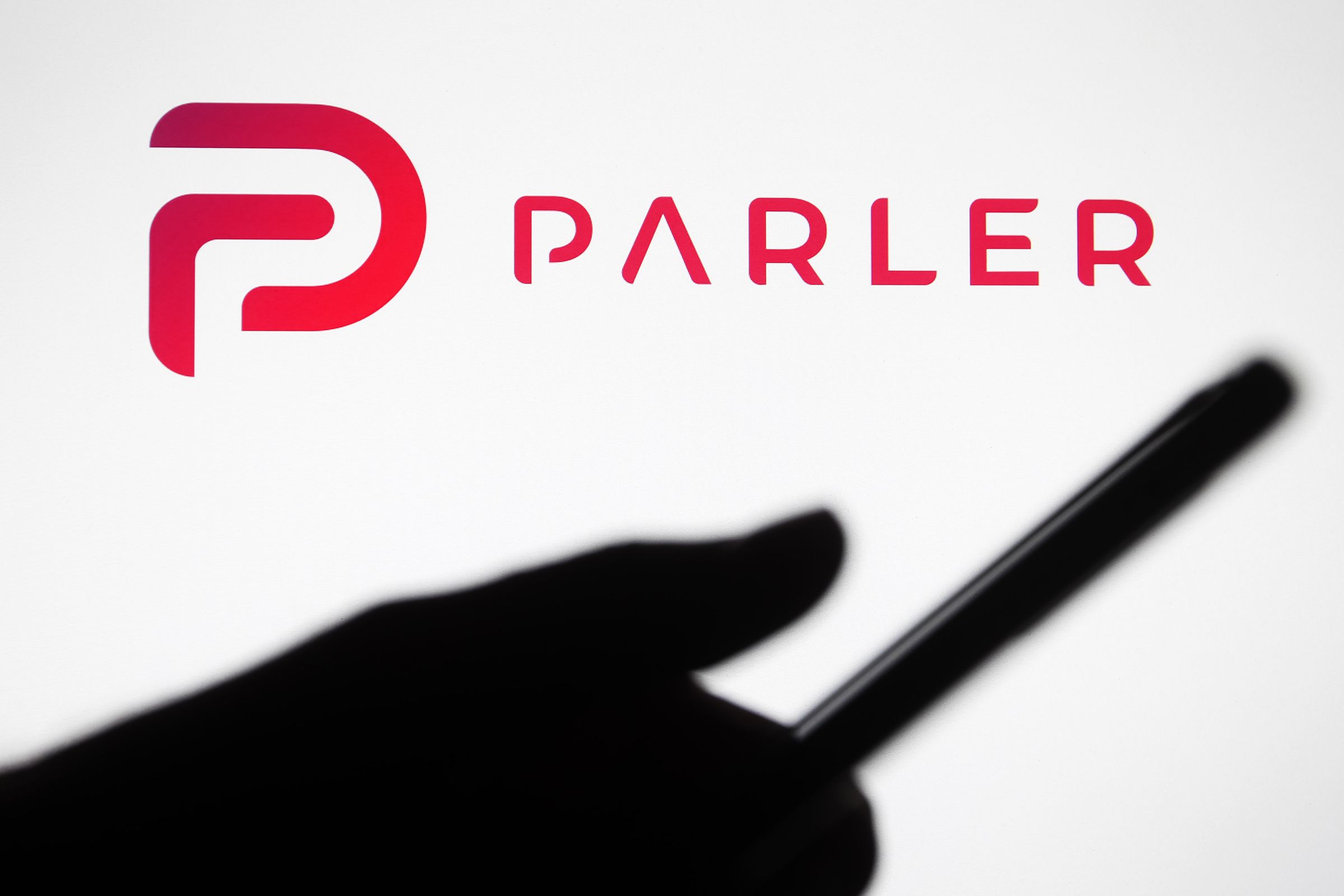 In this photo illustration the Parler logo seen in front of...