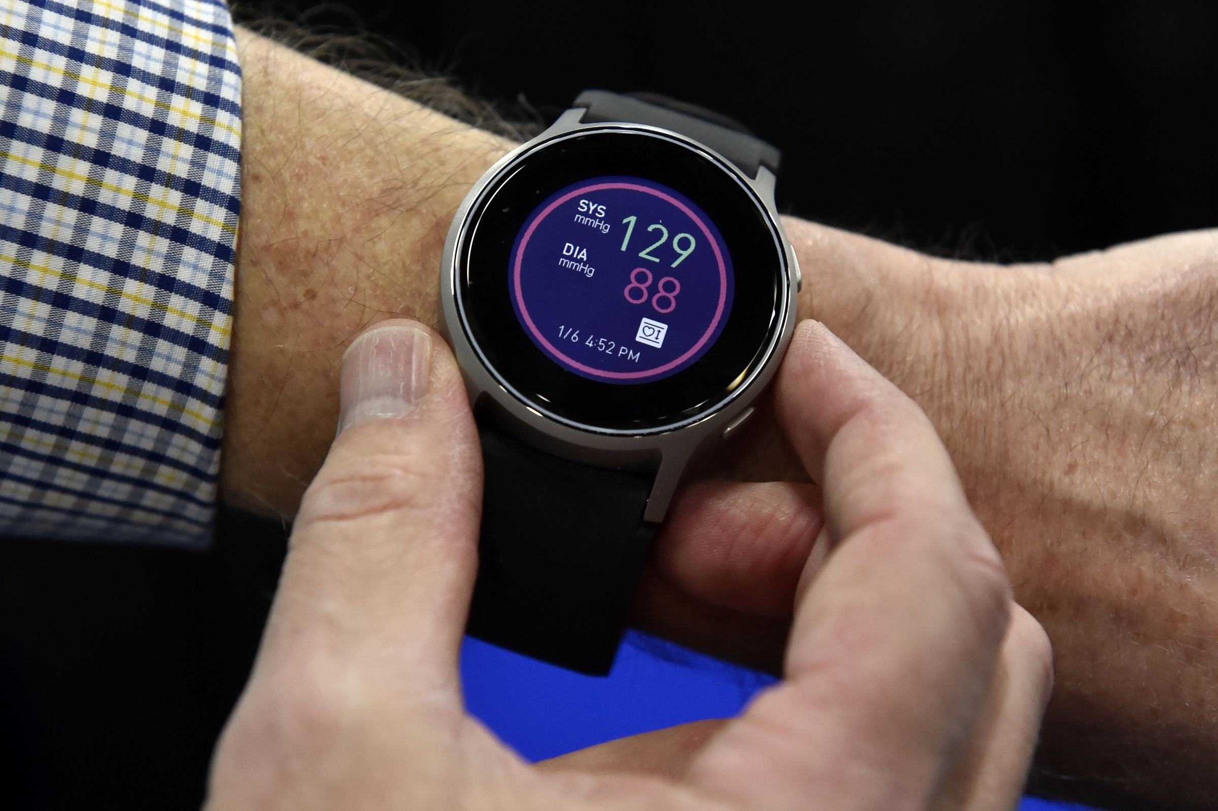 A watch displaying blood pressure reading on a person’s wrist.