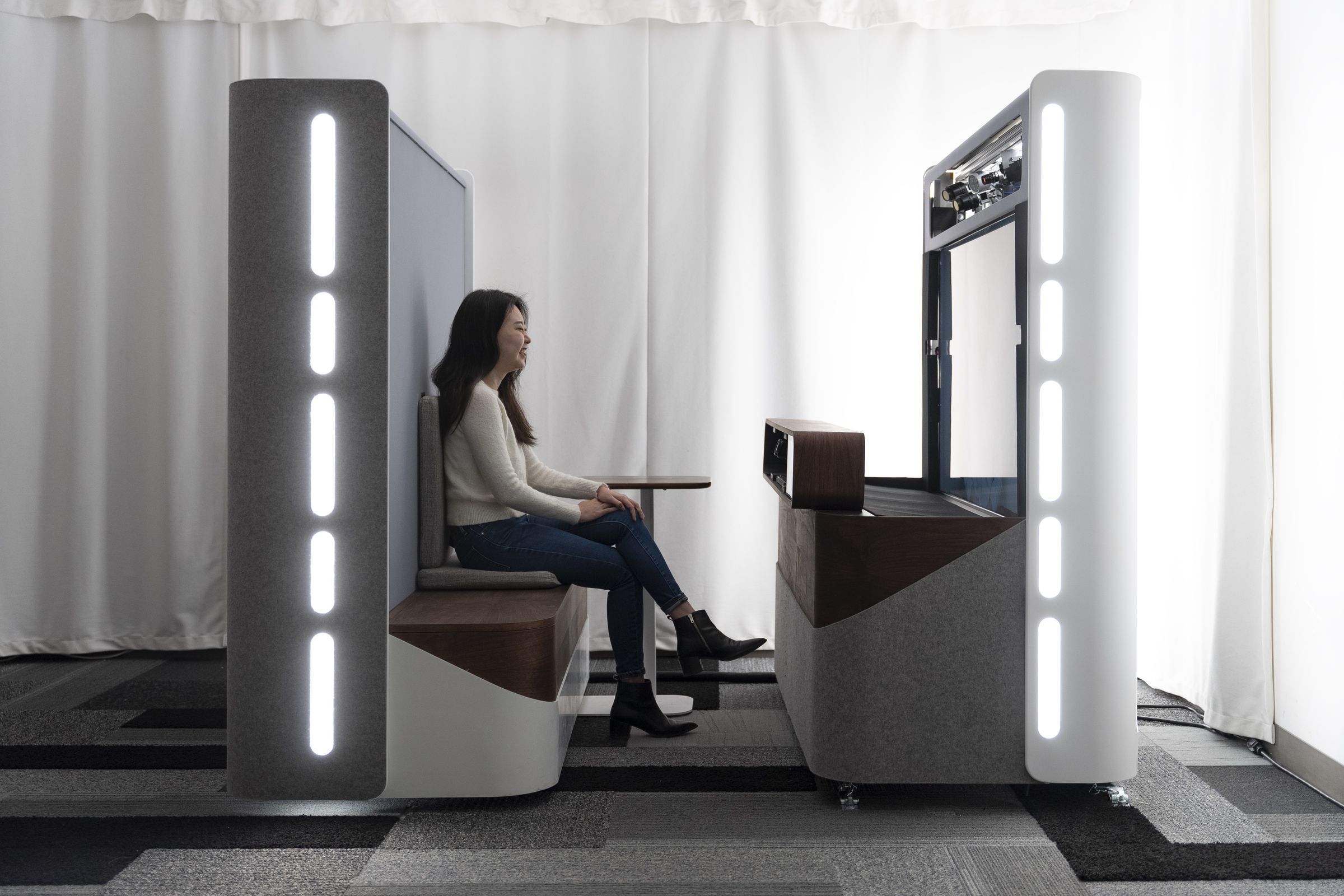 A person sits in one of Google’s Project Starline video chat booths.
