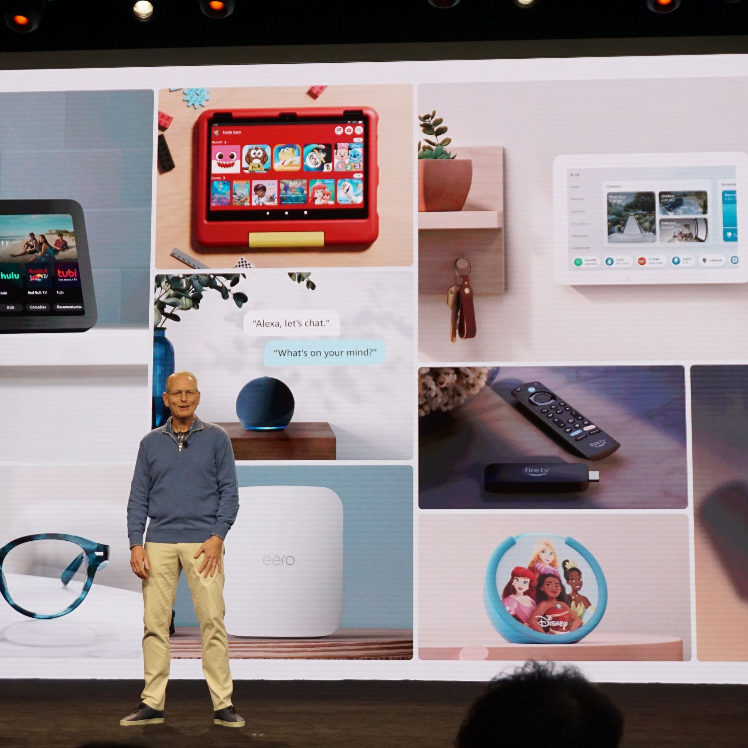 Man standing on stage in front of a projected image with Amazon’s new devices behind him