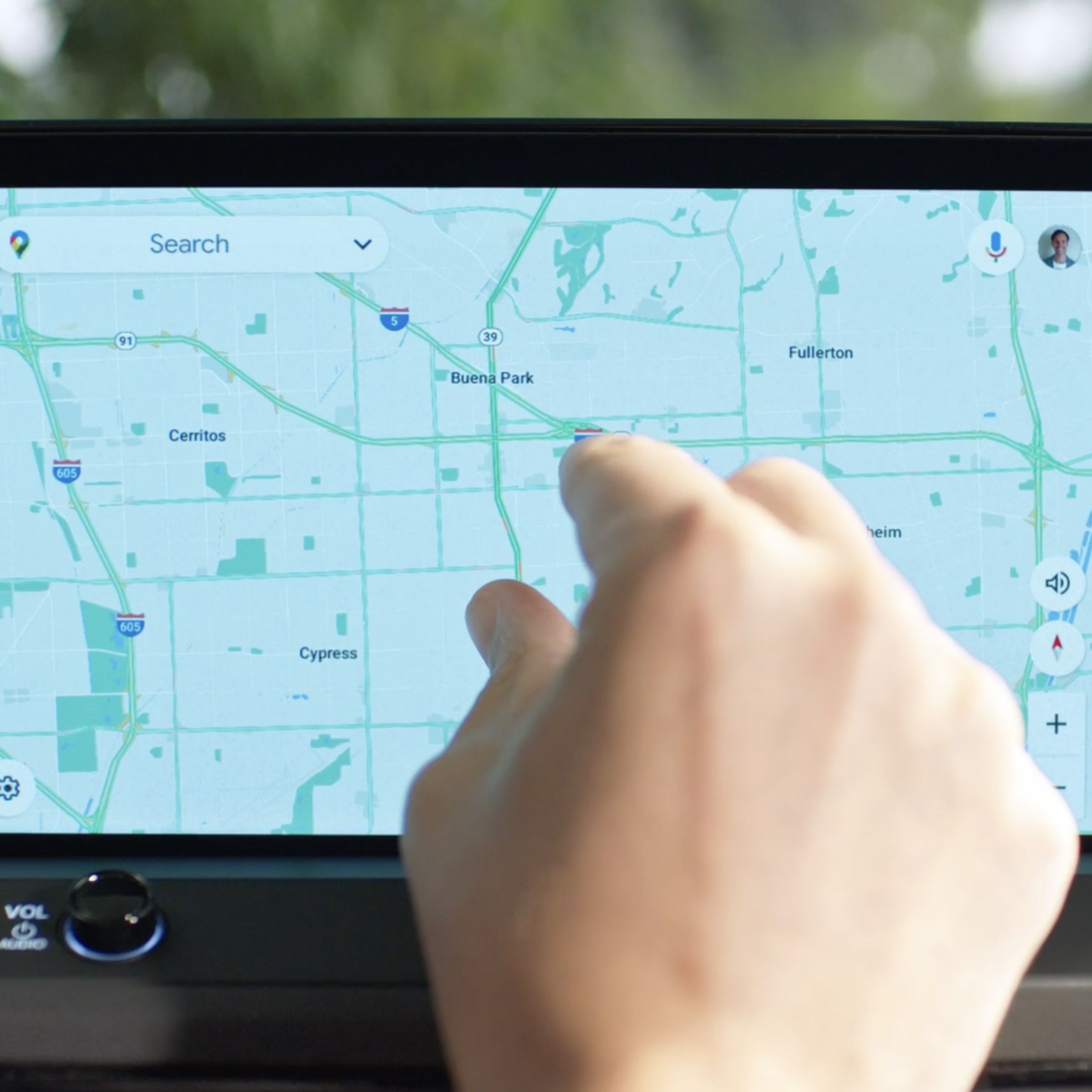 closeup of an infotainment screen in a Honda vehicle, with a hand pinching into the Google maps app.