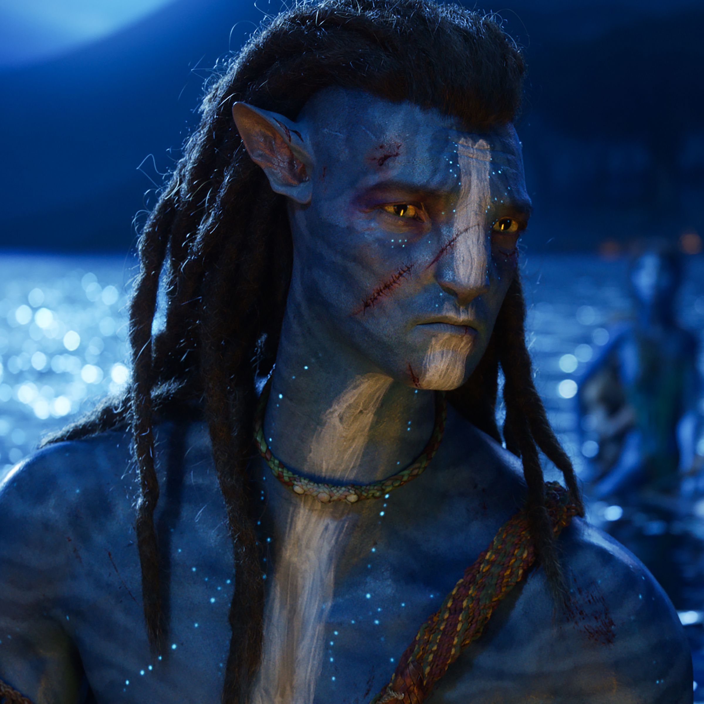 A blue humanoid being with feline features and a thick head of dreadlocks riding on the back of an animal in the middle of the ocean at night. In the background, you can see the moonlit sky and the moon’s reflected light bouncing off the surface of the water.