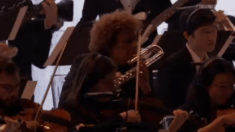 Gif of a curly haired man named Pedro Eustache playing an alto flute