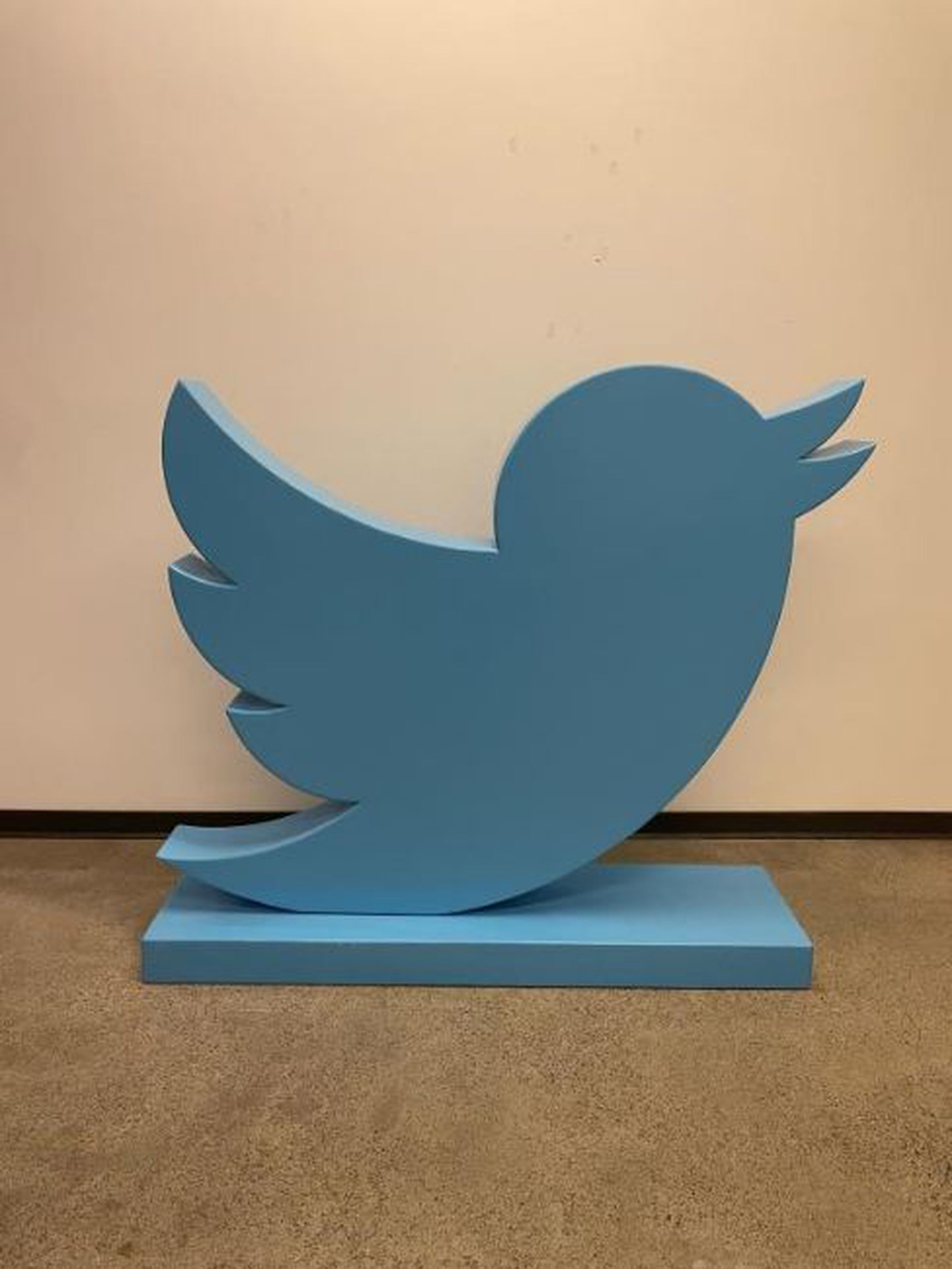 A large blue statue of the Twitter bird logo