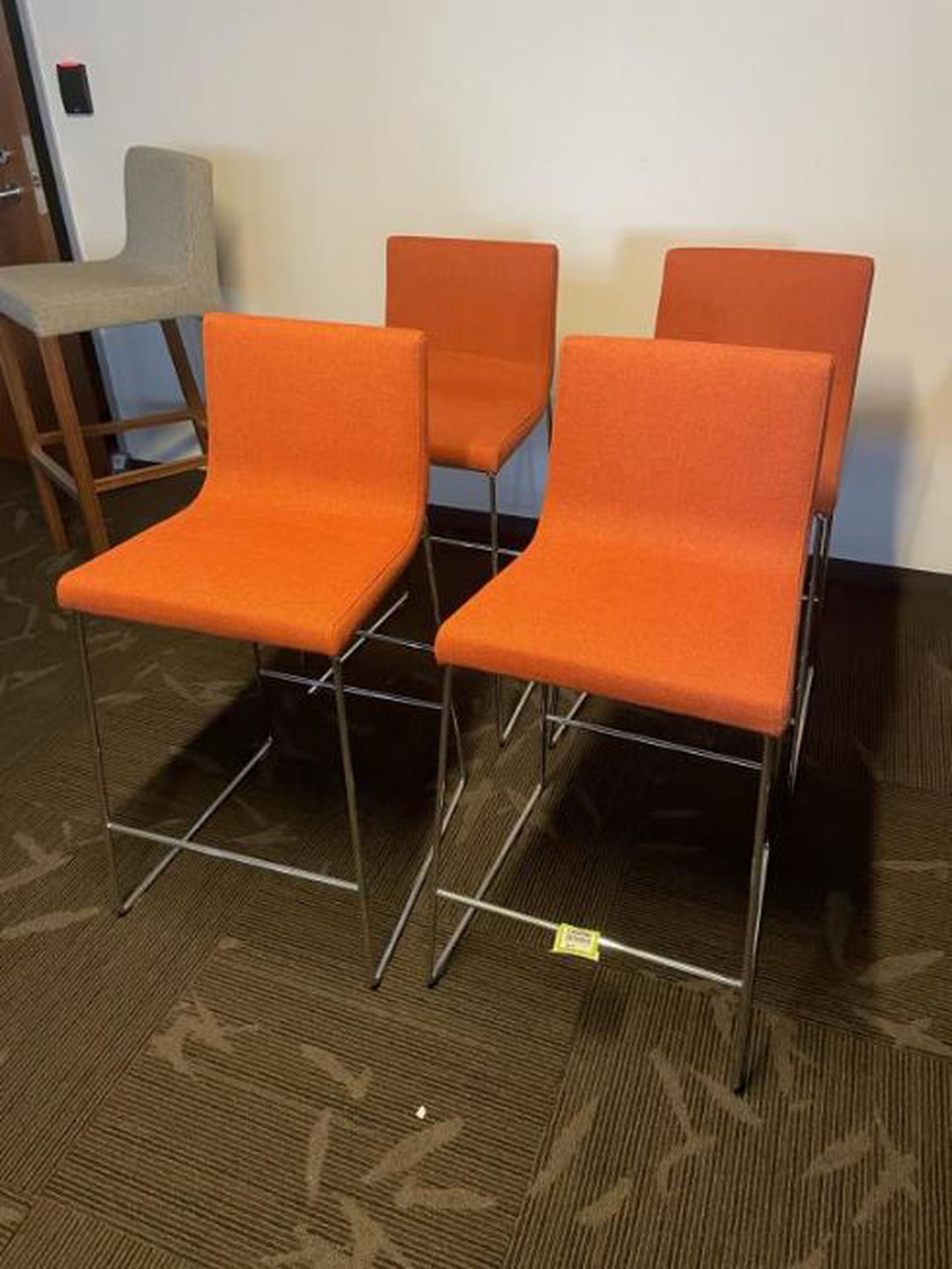 Four Andreu World Lineal Comfort counter stools in orange